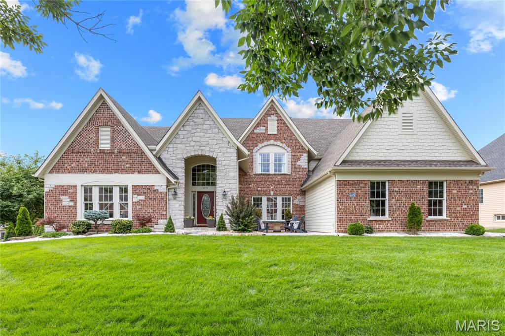 Spectacular Fischer & Frichtel-built 1.5 Sty situated on a premium lakefront lot in gated Spring Mill Estates. This beautifully designed residence blends classic architecture with carefully curated details for a refined living experience. Entering from the courtyard through the covered front porch & leaded glass entry door, the impressive oak-lined foyer leads to a private study and elegant dining room with octagonal ceiling. A 2-sty bow window provides a dramatic backdrop for the stunning great room filling the space with an abundance of natural light while offering expansive lake views. Off the main living area, the designer kitchen features 42-inch maple cabinetry, granite countertops, premium stainless steel appliances, butterfly center island & a convenient planning center. The adjoining breakfast room with wide bay window & hearth room highlighted by a brick & stone fireplace provide a welcoming gathering place. The coffered primary suite offers an appealing retreat with 2 walk-in closets and luxury bath with jetted tub. The 2nd floor extends the living area with 3 additional ensuite bedrooms. Atrium doors open to an inviting outdoor living area with composite deck and covered & open patios surrounded by professionally landscaped gardens. Located within walking distance of Wapelhorst Park with pavilions, trails & water park.