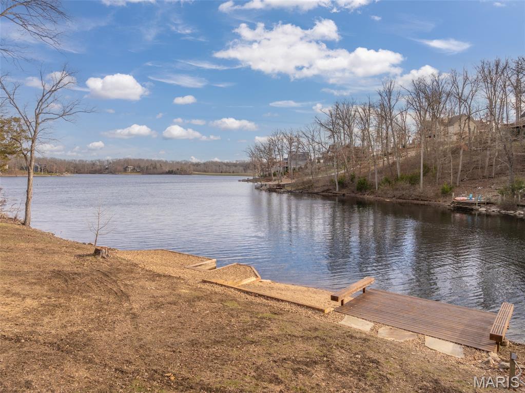 Discover the ideal setting for your future lakeside retreat with this beautiful 1+ acre lot on the shores of Lake Alpine—one of Missouri’s most scenic and best-fishing private lakes. Offering coveted southern exposure, the property welcomes warm sunlight throughout the winter months. A gentle slope leads effortlessly to the water’s edge, creating easy access for swimming, fishing, kayaking, and quiet boating. (Lake Alpine allows only electric trolling motors—no gas-powered boats—ensuring a peaceful, nature-filled experience.) The lot already features a private dock with electric, a boat mooring area, and a beach—so you can use and enjoy the lake even before building your home. The terrain is perfect for a custom home design with a walk-out lower level, and with no required construction timeline (restrictions and guidelines apply), you can build at your own pace. Nestled on a quiet, dead-end cul-de-sac and accessed by a blacktop road, the property offers both privacy and convenience. Nearby hiking trails, a community sand beach, and a gated entrance complete the setting. Serene, sunlit, and surrounded by natural beauty, this is your chance to own a truly special piece of lakeside paradise in Innsbrook.