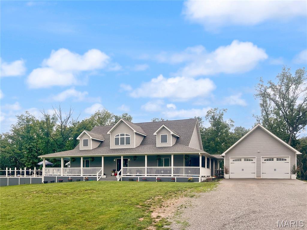 Custom-built home nestled on 21 scenic acres offering privacy, space, and stunning natural views. With over 3,000 square feet of finished living space, this home features an open-concept design with a spacious living room anchored by a gas fireplace, a dining area, and a beautifully appointed kitchen with custom wood cabinetry, solid surface countertops, stainless steel appliances, and a walk-in pantry. A mudroom connects the kitchen to the  two-car garage for everyday convenience. The thoughtfully designed main level includes a private primary suite with direct access to the wraparound porch, his/hers closets, and a luxurious ensuite bath featuring double vanities, a walk-in shower, and a soaking tub. A second bedroom and full bath are located on the opposite side of the home, providing excellent separation and privacy. The finished walkout lower level expands the living space with two additional bedrooms, a home office/sleeping room/gym, full bathroom, large family room, bar area, an additional laundry hookup, and ample storage. Outdoor enthusiasts will appreciate the 40’ x 28’ detached heated outbuilding- perfect for an RV. The outbuilding features heated flooring, a full bathroom, and another laundry hook-up. Wooded acreage with trails, deer stands, and abundant wildlife. Relax on the wraparound porch overlooking the peaceful setting, complete with a POOL! This exceptional property offers the perfect combination of comfortable living, recreation, and country tranquility.