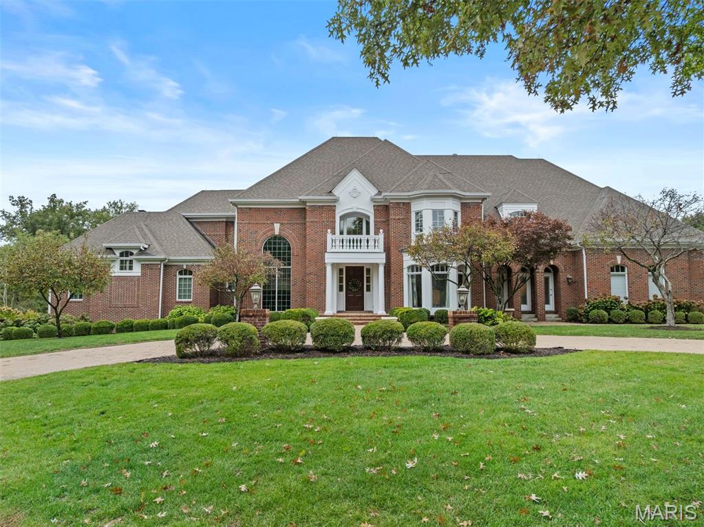 Tucked within a gated enclave in the heart of Frontenac, this exceptional Johnson Homes residence defines the art of sophisticated living. Set on a private, park-like acre, the home blends timeless architecture with modern livability. A grand foyer opens to light-filled, open-concept spaces designed for both daily comfort and effortless entertaining. The designer kitchen is anchored by an oversized island and framed by custom cabinetry and professional-grade appliances, flowing seamlessly into the great room with walls of windows and views of the lush grounds. A formal dining room sets the stage for elegant gatherings, while the study offers a refined retreat. The main-floor primary suite is a serene sanctuary with dual walk-in closets and a spa-inspired bath. Upstairs, a secondary primary suite and two additional bedroom suites provide comfort and style for family and guests alike. The lower level transforms entertaining with a full bar, theater, billiards room, library, and soaring ceilings. Two bedrooms and full baths for extended stays. Dual decks overlook the resort-style pool, putting green, and manicured landscape, an idyllic backdrop for summer nights. A mudroom, main-floor laundry, and four-car garage enhance functionality, while a whole-home generator ensures peace of mind. Every detail reflects craftsmanship, comfort, and enduring elegance, a Frontenac address of rare distinction.