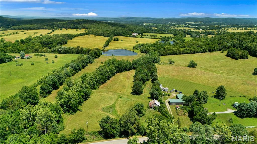 Set on the outskirts of Fredericktown, this exceptional 106 acre farm offers a rare blend of productivity, natural beauty, and privacy. Rolling hills and expansive views create a picturesque backdrop for a wide range of agricultural or recreational uses. Water resources are abundant and dependable, including a private lake, natural spring, Mitchell Creek, and the newer deep water well with larger pump for increased pressure—providing excellent support for farming, livestock, and long-term sustainability. The pristine 5 acre lake is teeming with bass for your fishing enjoyment. Perfect for off-grid living or weekend get-away camping with two RV campsites having separate 200 amp electric service, well, and leased propane tank already in place. The infrastructure is well-positioned for expansion, additional dwellings, or diversified agricultural use. There are multiple homesites with fantastic views for a future forever custom dream home. The property features a mix of cleared hay fields and pastureland (70%), well-suited for cattle grazing or other livestock operations. Two stall barn in place with room for more and accessory buildings offering immediate utility for equipment storage. A combination of fencing, open ground, and gently rolling terrain makes it both functional and easy to manage. A vintage barn anchors the picturesque landscape. Tucked away in a private setting, the land offers peace and seclusion without sacrificing usability. Venture out to enjoy the St. Francis River, Mark Twain National Forest, Marble Creek recreation area, and the beautiful Ozark mountains. Whether you're looking to establish a working cattle operation or create a legacy homestead, this property delivers space, water, and versatility in one remarkable package. Build your dream estate here. This exceptional property combines immediate agricultural revenue with ultimate flexibility. Featuring established hay fields, incredibly low property taxes, and complete absence of restrictions, this farm is a premier investment. Located just 90 minutes from the St. Louis metro area and a short trip from the ever growing town of Fredericktown. Twenty-five minutes from the Historic Downtown District of Farmington and the new Farmington Crossings open air mall that will feature Target, Academy Sports, and Burlington. Duplicate Listing of MLS # 26039325