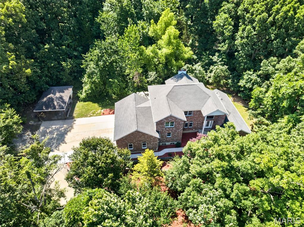 If you'd like all the amenities of beautiful home but more than a postage stamp lot...this custom-built house is for you! Situated on a 5-acre wooded lot just a few minutes drive from I-55, it has a gorgeous 2-story living room area with great windows and dramatic fireplace. The kitchen is beautifully appointed, and there is a windowed breakfast room nearby with a view of the woods. You will be impressed by the detail work and craftsmanship in this home, skillfully done by the seller, who is himself a carpenter. The primary bedroom suite is on the main floor with a stunning bathroom, walk-in closets and even its own walk-out to a cozy, shaded sitting area. Upstairs, there are 3 bedrooms, and a jack-and-jill bath. There's even a bonus area perfect for a study or reading nook. The lower level is partially finished, and could be a family room, office, or even a bedroom since there is a full bath. Enjoy grilling out and entertaining on the back patio. There's a carport on the property that can be used for a boat, if you'd prefer! What a lovely place.