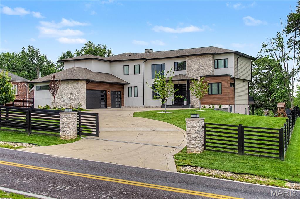 Stunning 7 bed, 6.5 bath custom-built 2023 estate on over an acre. Striking curb appeal with granite front porch and modern design. Step through custom double doors into a bright, open layout featuring soaring ceilings, hardwood floors, glass railings, and intricate millwork. Chef’s kitchen boasts 48” pro range, 12’ waterfall island, quartz tops & backsplash, custom glass cabinetry,microwave drawer, bev center, built-in fridge, and sleek design. Dual primary suites—one on each level—include spa-like baths with freestanding tub and walk-in showers. Upstairs offers 4 beds, 4 full baths, and 2nd laundry. Finished lower level with rec room, wet bar, sauna, and bed/bath. No detail overlooked: 2 high-efficient HVAC's, 2x6 construction, camera system, spray foam insulation, 400 amp service, covered deck/patio, heavy glass & custom tile work in baths, oversized 3-car garage, and custom built fencing w/ dual auto gates.Exceptional blend of luxury, style, and function—truly one of a kind!