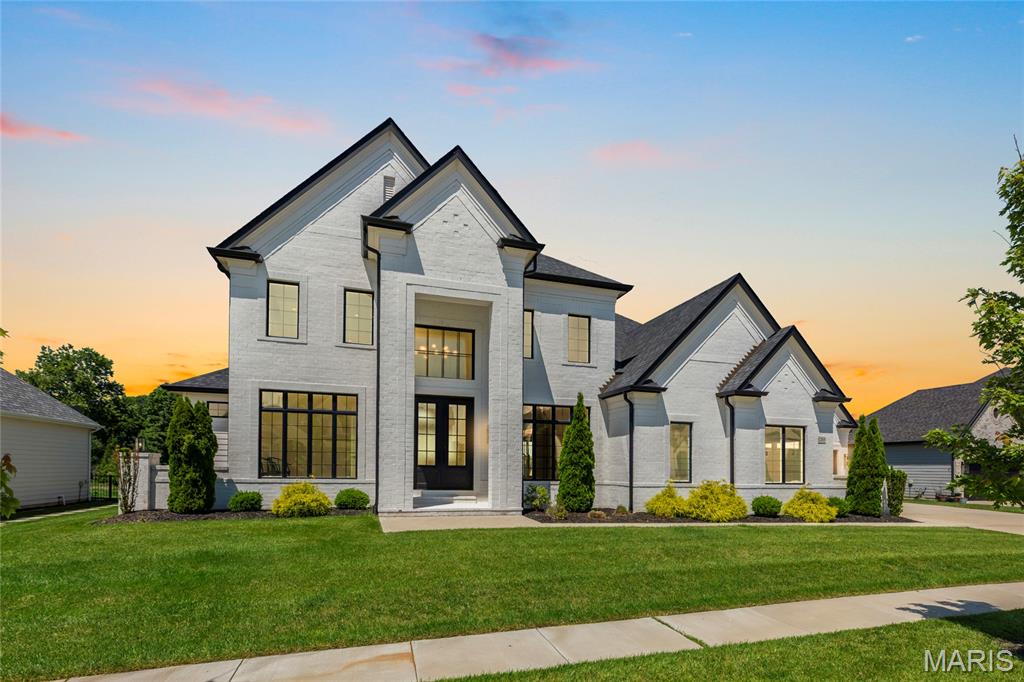 Located in the prestigious Fienup Farms community, 1205 Patchwork Fields is a masterfully crafted estate where modern sophistication meets effortless luxury. Built in 2021 by Claymont Development, this extraordinary 1.5-story residence offers more than 6,600 square feet of impeccably designed living space, curated for both grand-scale entertaining and elevated everyday living.

Beyond the dramatic two-story foyer, sunlit interiors unfold with soaring ceilings, walls of windows, designer finishes, and a seamless open-concept floor plan that exudes contemporary elegance. The chef’s kitchen is a statement in refined luxury, featuring premium Thermador appliances, quartz surfaces, an expansive walk-in pantry, and sophisticated custom detailing designed to impress even the most discerning buyer.

The main-level owner’s retreat is a private sanctuary, complete with spa-inspired bath amenities and oversized dual dressing closets that rival boutique couture spaces. Upstairs, find three thoughtfully-designed bedrooms -- one en suite and two sharing a spacious jack-and-jill bath. A well-sized lofted space offers a wall of windows with stunning western views.

The finished walk-out lower level elevates the home’s entertaining capabilities with a spacious recreation lounge, wet bar, guest suite, and effortless indoor-outdoor flow.

Thoughtfully appointed with zoned HVAC, tankless water heating, integrated security, sprinkler systems, and a four-car garage, every detail reflects uncompromising quality and intentional design. Outside, expansive outdoor living spaces capture breathtaking sunset views.

More than a residence — it is a rare lifestyle offering in one of Chesterfield’s most sought-after luxury enclaves, blending architectural excellence, resort-style amenities, and timeless elegance into one unforgettable home.