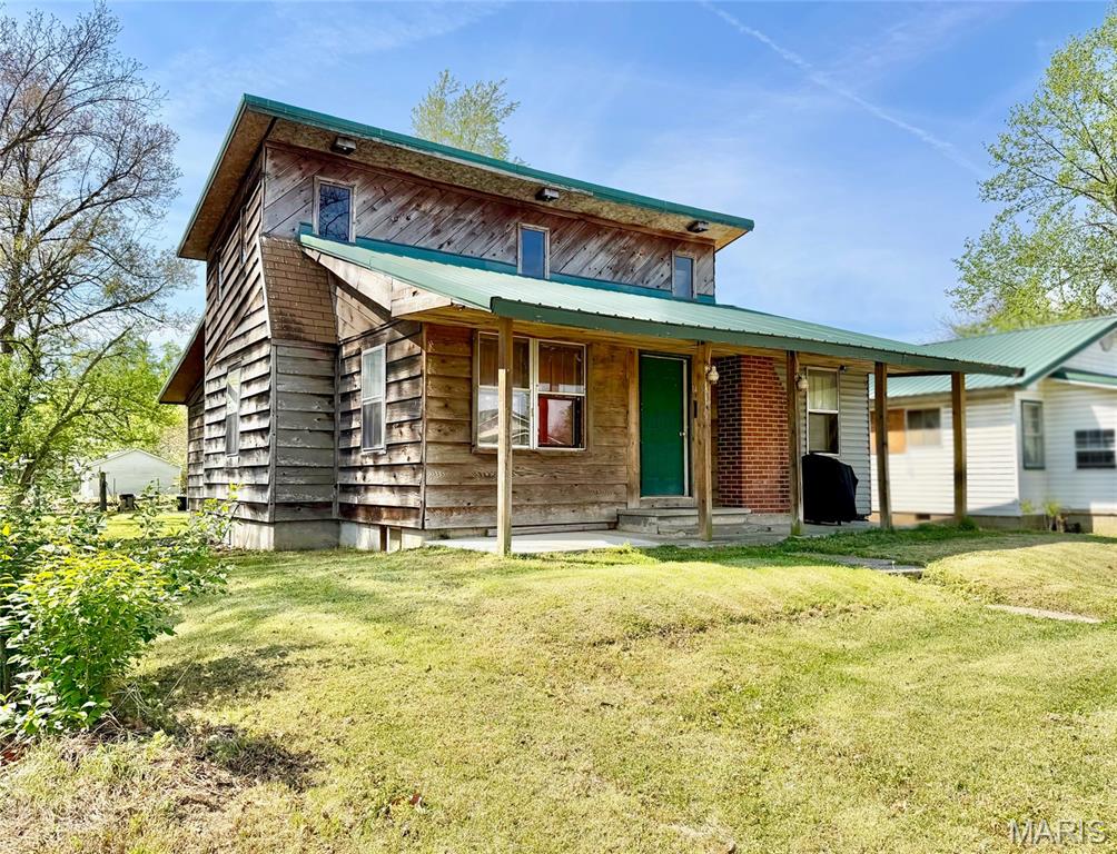 Opportunity awaits with this spacious 4-bedroom, 2-bath home offering approx 1875 sq. ft. of living space in a 1.5 story layout. This home features central heat & air, metal roof, & a rock fireplace that adds to the rustic character of this home. Enjoy outdoor living with french doors leading to a deck, plus a 6x20' covered front porch - perfect for relaxing evenings. Home also includes a basement for additional storage or workspace, and there's a separate storage shed. Alley access to the rear of the property. This home has alot of character but needs a few updates....it's perfect for investors, flippers, or buyers looking to create their own vision. This is a great chance to own a large home at an affordable price! *Fireplace vent has been covered over.