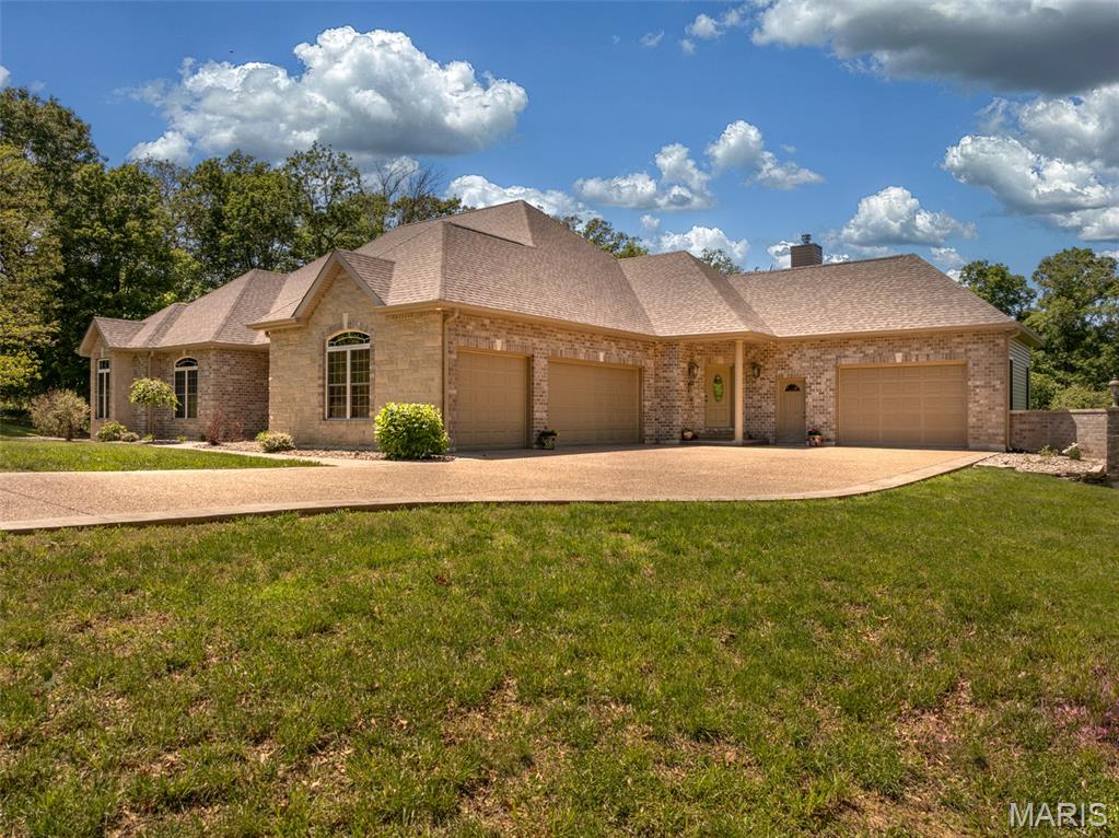 LOCATION is perfection! Travel down a paved road and arrive at your custom ranch home, with double garages, a finished basement, stunning seller/builder details with over 5,000 total finished SF! I need way more space here to describe all of the features. Large kitchen with second dining / living area arranged around the Buck stove fireplace. Brazilian cherry flooring, double wall ovens, long peninsula and island, custom cabinets and tile backsplash. Seller just had a new refrigerator installed in March of 2026.  Living room has 12 foot coffered ceilings, Hickory flooring, a second stone fireplace surround, with a 3 season room to enjoy the scenery. Open dining room connects fully to the living room. On the main floor there are 3 bedrooms, an office, and 2.5 baths. Main floor laundry is just off garage entry area. The primary bedroom features an ensuite that is fully custom with a tiled shower, double showerheads, a soaking tub, and walk-in closet. The other 2 bedrooms are connected with a generous Jack in Jill bathroom. Office has large window overlooking backyard and double doors on the entrance. The lower level is unlike any basement you have ever seen! Wine room, bar, movie viewing area, sleeping area and 3rd full bathroom. There is a workout area and unfinished space for storage. The basement level walks out to the deck, enjoy the privacy and woods that back to this property. You have 3+ acres, plenty of room here! Landscaping and custom stamped and exposed aggregate concrete round out this beautiful property, must see in person to fully appreciate it! Located in the heart of Defiance, MO Wine country and biking and region. Please schedule a showing to see this splended home in person!
