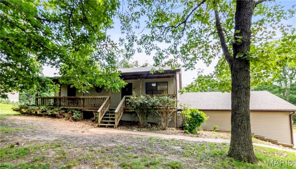 Welcome home to this versatile property nestled among mature trees in the heart of Gerald, offering a peaceful setting with NO HOA restrictions. Enjoy quiet mornings from the covered front porch, the perfect spot for sipping your morning coffee while taking in the surroundings. You'll love being just minutes from Gerald City Park, schools, and local amenities.

Step inside to discover an open floor plan featuring a vaulted ceiling in the living room that enhances the sense of space. The main floor primary suite offers everyday convenience with a spacious layout. The main level also includes two additional bedrooms, a second full bath, and a convenient half bath. Recent updates include fresh interior paint and upgraded main-level light fixtures.

The walkout basement offers flexible living space and room to grow, featuring a private sleeping room, a full bathroom with a step-in shower, a separate workshop with its own garage door access, an oversized tuck-under two-car garage, and additional unfinished space ready for storage, hobbies, or future finishing as your needs evolve.

Outside, the backyard includes a fenced area ideal for pets, gardening, or backyard hobbies, while the mature trees provide a peaceful backdrop. Whether you're looking for extra space, functional storage, or the opportunity to make a home your own over time, this property offers a convenient location near parks and community amenities. A Choice Home Warranty is included for your added peace of mind.