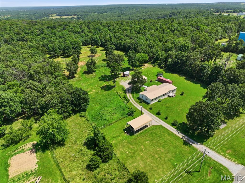Looking for room to spread out without sacrificing convenience? This beautifully maintained 4-bedroom, 2-bath manufactured home sits on a permanent foundation and offers the perfect balance of peaceful country living and everyday accessibility. Nestled on 5 picturesque acres, you'll enjoy the privacy and freedom you've been searching for while remaining just minutes from local shopping, scenic trail riding, hiking, the Mark Twain National Forest, and only a short drive to Fort Leonard Wood. Step inside to discover a spacious, thoughtfully designed floor plan featuring two inviting living areas, a dedicated office or den perfect for working from home, and a large kitchen complete with a center island and abundant cabinet space to keep everything organized. Whether you're hosting family gatherings or enjoying quiet evenings at home, there's plenty of room for everyone to feel comfortable. Outside, the property is equally impressive with a fenced area ready for farm animals or pets, making it ideal for hobby farmers or anyone who loves the outdoors. A 24x30 carport with a roll-up door, an 18x35 partially covered RV canopy, and a 40-foot storage container with electricity provide exceptional space for vehicles, equipment, hobbies, or additional storage. A new front porch and back porch handrails add both curb appeal and convenience. If you've been dreaming of acreage, versatility, and a home that's move-in ready, this property checks all the boxes. Schedule your private showing today and experience everything this exceptional property has to offer!