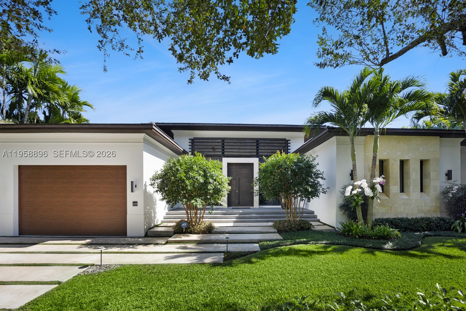 Experience modern luxury in the heart of Coral Gables. Designed for effortless living and entertaining, the open floor plan features volume ceilings and seamless indoor-outdoor flow. The Italian MiaCucina eat-in kitchen is a showpiece with Sub-Zero, Perlick, and Wolf appliances, custom bar and wine display, and a walk-in pantry with integrated laundry, including a custom 2 drawer Perlick refrigerator for convenience. The primary suite is a private retreat overlooking the pool, offering a large walk-in closet, an additional walk-in storage closet, and a spa-inspired bath with an oversized rainfall shower, floating vanity, and dual sinks. Outdoors, enjoy a saltwater pool with state-of-the-art heater and chiller, a private outdoor shower, and a custom-designed outdoor kitchen with a Fire Magic built-in grill and Perlick cooler. Additional features include Lutron smart home technology and a double-height garage ceiling built to accommodate a car lift. The home is equipped with integrated high-definition security cameras and a state-of-the-art security system for peace of mind. Enjoy Sonos audio throughout the main room, kitchen, master bath, and lanai, as well as Sony Master Series TVs in the main room, master suite, office, both guest bedrooms, and workout room. Magnificent landscaping too!