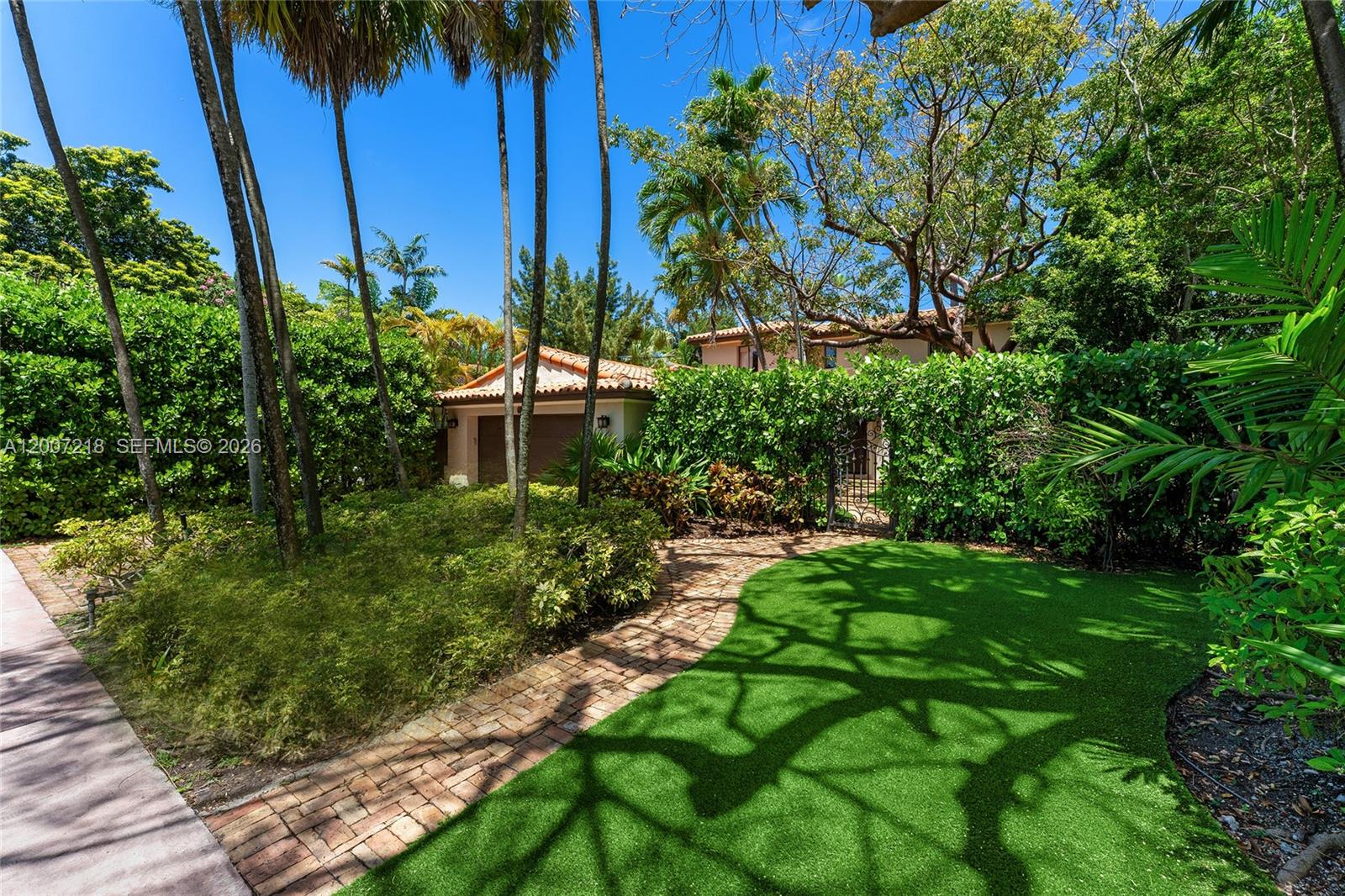 This enchanting 2-story Mediterranean Spanish style villa sits on a 7,500 SF lot, offering 4BR (including staff with full bath) and 3 full bathrooms plus 1 half bath. Fully gated with lush mature landscaping, soaring palms, and a Chicago brick driveway leading to a serene interior courtyard with shade trees and seating. Features include a barrel tile roof, 2-car garage, and additional parking. Spacious living room with wood-burning fireplace, terracotta picket-and-square-set tile floors, and courtyard views. Family room sits just beyond with direct access to the pool deck. Private dining area connects seamlessly to the kitchen and opens to the backyard. Kitchen features Crema Marfil marble floors, quartz countertops, refinished cabinetry, gas cooktop, new KitchenAid refrigeration, and Maytag dishwasher. Staff bedroom with en-suite bath and full laundry room with a brand-new washer & dryer complete the first floor. Upstairs, the principal suite offers high ceilings, dual closets, courtyard views, and a spa-style bath with soaking tub and glass shower. Two additional bedrooms share a full bath in the hallway. Backyard highlights include a Chicago brick deck, coral stone rimmed pool, and multiple seating areas. Ideally located just a 10–15-minute walk to pristine beaches, with access to world-class dining, fine shops, top-rated schools, golf courses, Downtown Miami, cultural/sporting venues, and Miami International Airport.
