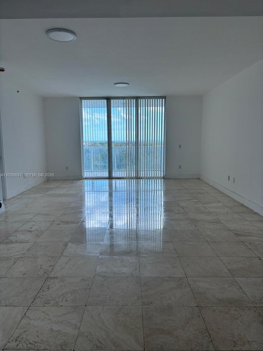 Spacious and bright 2-bedroom + DEN corner unit with elegant marble flooring in the main areas and luxury wood-look vinyl flooring in the bedrooms. Features a modern European-style kitchen with granite countertops, in-unit washer & dryer, and a spacious primary bathroom with marble finishes, jacuzzi tub, and separate shower. Excellent layout with high ceilings and plenty of natural light. Located in a gated community with resort-style amenities including 24-hr security, concierge, heated pool, fitness center, tennis courts, clubhouse, lounges, playroom, dog park, and valet. Prime location close to Aventura Mall, FIU Campus, Costco, restaurants, and more. BASIC CABLE & INTERNET INCLUDED.  Unit includes 1 assigned parking space. Additional parking available through the association: 2nd space $65/month and 3rd space $125/month.