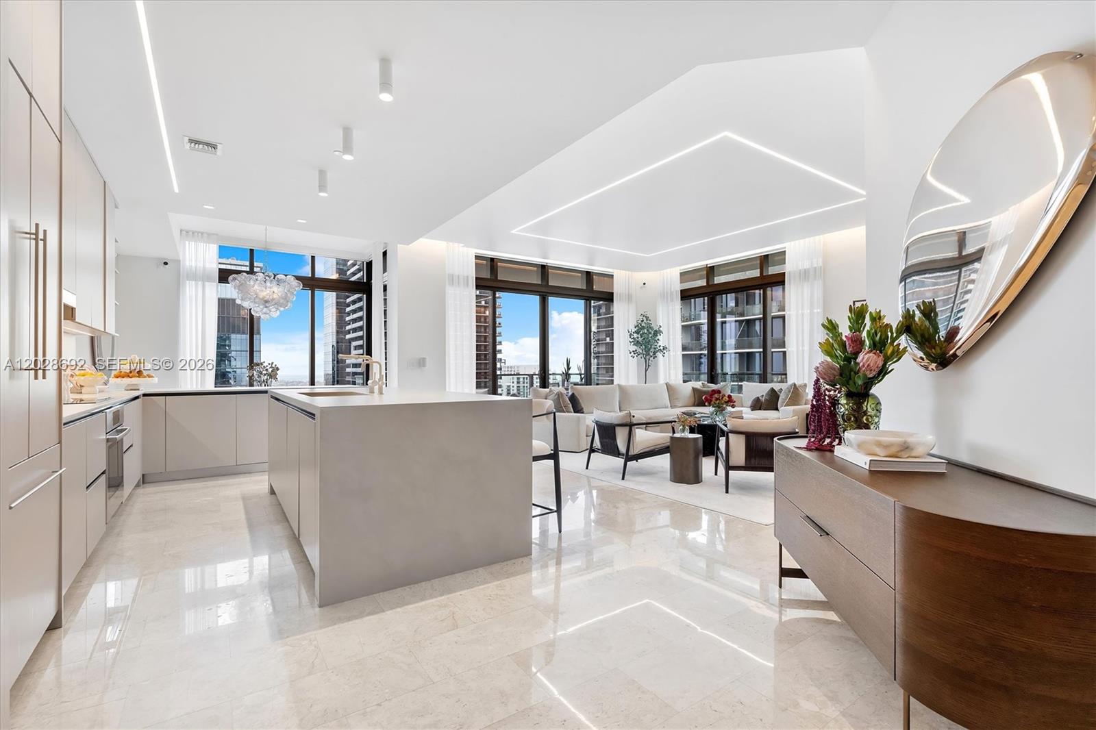 Experience a level of design and sophistication rarely seen in Brickell. This Tower Suite penthouse spans 3,244 SF of impeccably redesigned interiors with 4 bedrooms, 4.5 baths, staff quarters, and over 738 SF of terraces showcasing 180-degree views of the Miami skyline, and Biscayne Bay. One of only 10 exclusive Tower Suites in the building, this sky residence has undergone over a half-million dollars in bespoke designer renovations, transforming it into a true statement property. Every detail was curated by a professional interior designer, creating a seamless blend of modern elegance, warmth, and architectural sophistication.The completely reimagined chef’s kitchen features sleek integrated appliances, custom cabinetry, premium finishes, and an open-concept design ideal for entertaining. The expansive living spaces are enhanced by custom architectural cove lighting with integrated linear LEDs, programmable smart-home automation, surround sound, curated art, and statement chandeliers that elevate the residence to a gallery-like experience. The primary suite offers a private retreat in the sky a newly redesigned bathroom featuring a soaking tub, designer vanities, premium fixtures, and refined finishes throughout. Floor-to-ceiling glass, 12-foot ceilings, and expansive terraces create seamless indoor-outdoor living with panoramic water and city views from nearly every room. Custom designer furnishings are included.
