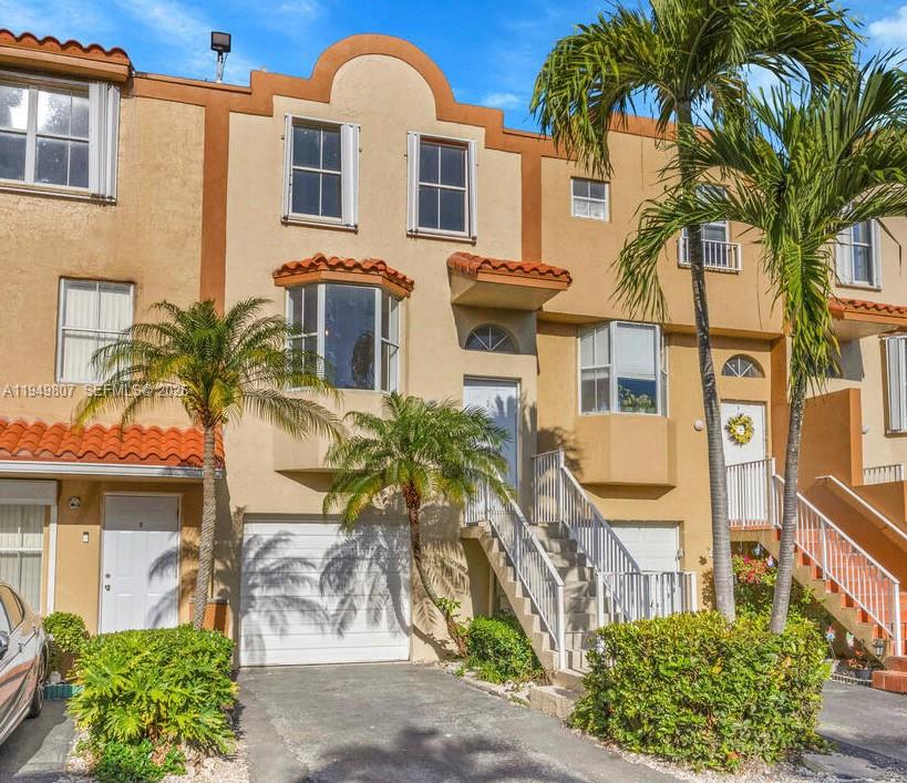 Completely renovated tri-level townhome with oversized yard and 1-car garage in Riviera at Coral Lakes community. Features separate living, dining, and family rooms, a new kitchen with wood cabinets and stainless steel appliances, new laminate wood floors, and updated bathrooms. Accordion shutters throughout. Enjoy community amenities including a pool.