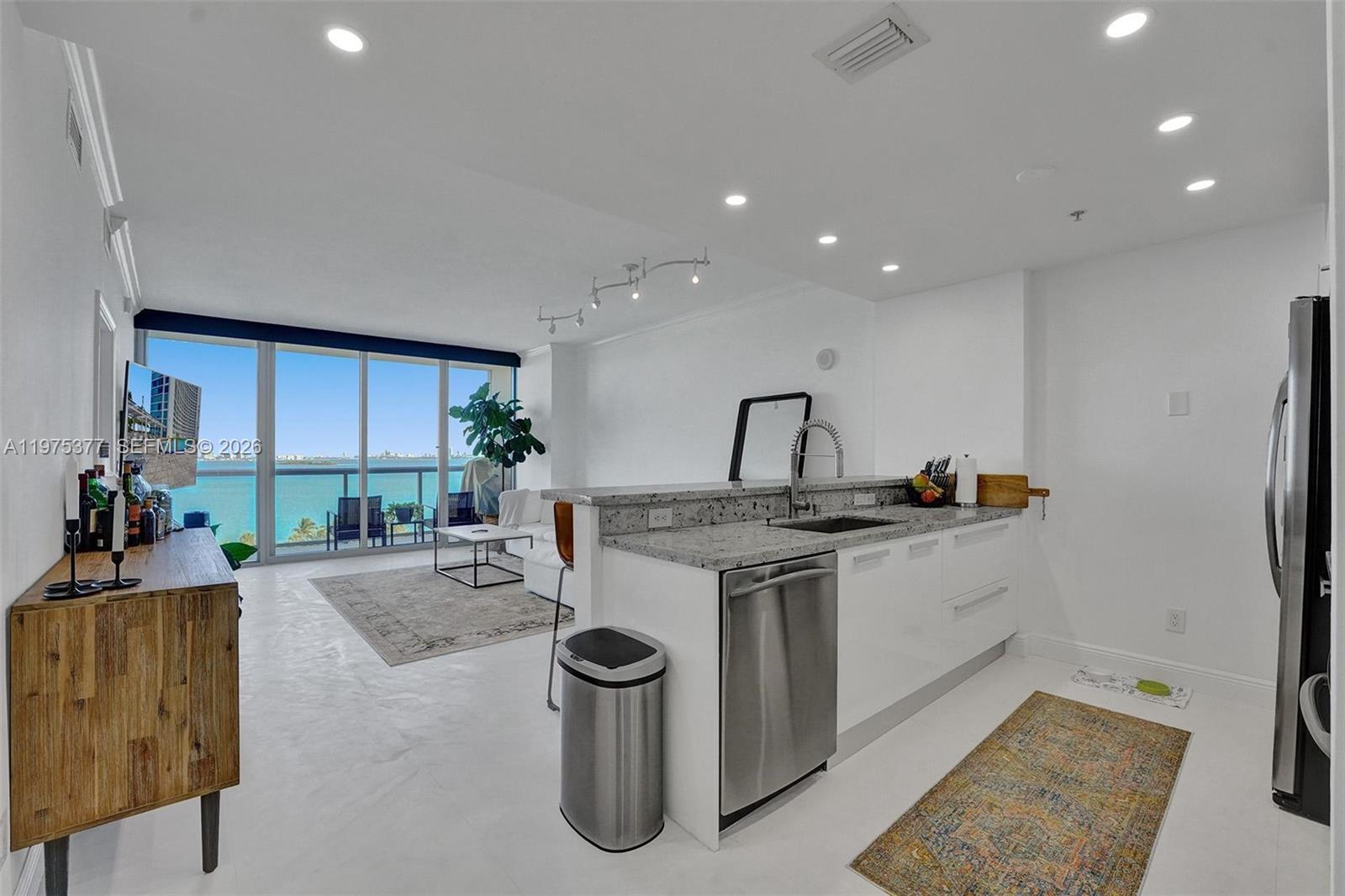 Unobstructed jaw-dropping water views from the moment you step inside the most desirable biggest sqft one bedroom line in the building with upgrades like Black Out and Privacy shades, new washer & dryer in unit, big deep kitchen sink, extended granite countertop, Wood Built-in Master Closet, Master bath includes dual modern sinks huge bathtub/shower combo, limestone marble floors, Italian modern kitchen cabinets with stainless steel appliances. Amenties galore! Front desk 24 hr concierge service, Convenient Store, awesome parking system, multiple heated swimming pools, theatre, party, kids, office rooms. Storage locker. Located in a conveniente area north of edgewater near by is Wynwood, Design district,Miami Beach. Staff makes you feel like family. 2 parking spots!