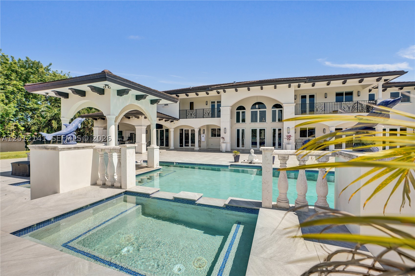 A secluded, gated estate in the heart of Horse Country, this nearly 2-acre property blends architectural artistry with resort-level living. Behind custom wooden doors, soaring ceilings and walls of impact glass set the tone for a home designed around light, scale, and connection to nature.
    With 12,804+ SF, the residence offers 8 bedrooms, 9 full bathrooms, 2 (1/2) baths, an elevator, dual staircases, and expansive terraces off every room. The chef’s kitchen centers around a dramatic marble island and is complemented by multiple midnight bars and a full outdoor kitchen.
    The first level includes two bedrooms, two offices, a children’s playroom/study area, theatre, and gym. Upstairs, six bedrooms and a private family room. The grand primary suite with dual walk-in closets, spa bath, and steam sauna. Outdoors, lush grounds surround an infinity saltwater pool with jacuzzi, waterfall, summer kitchen, and a full outdoor bathroom. The property is lined with an extraordinary collection of fruit trees—mango, soursop, avocado, dragon fruit, plantains, mamey, and more.
   Additional features include washers/dryers on both floors, a 3-car garage, ample parking, security system, and a newer flat tile roof.