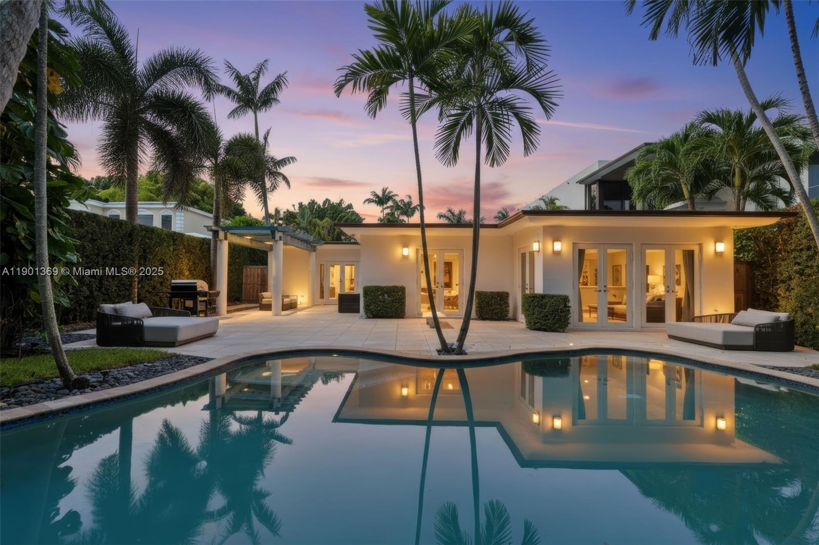 Nestled on a lush 12,000SF Lot along prestigious North Bay Road, this elegant 5-Bed, 3.5-Bath single-story residence combines modern sophistication with timeless charm. Bright & open interior features floor-to-ceiling windows, glossy porcelain floors, and living areas ideal for entertaining. A sleek modern kitchen showcases high-end appliances and custom cabinetry, while the formal dining room doubles as an art showcase. Enjoy a built-in bar, media room, and seamless flow to the private outdoor oasis with a heated pool and tropical landscaping. Additional highlights include a double garage, water filtration system, Generac generator and security system. This home offers the ideal balance of comfort, design, and functionality. Moments from the best of the ocean and La Gorce Country Club.
