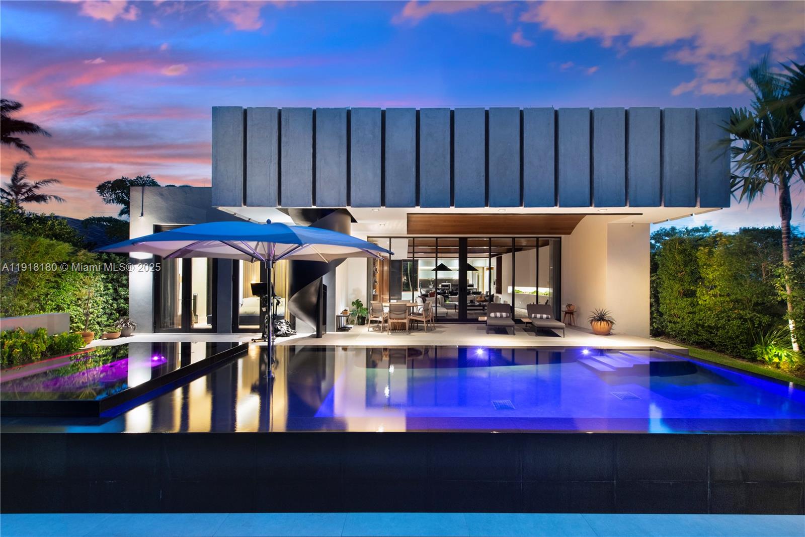 Located within a 24/7 guarded waterfront enclave and less than half a mile from one of Miami’s top-rated schools, this modern waterfront residence offers direct ocean access with no fixed bridges. Combining international craftsmanship, advanced technology, and serene design, the home features impact-resistant glass, Fleetwood sliding doors, app-controlled Lutron lighting, and hidden blackout shades in all bedrooms. Italian kitchen cabinetry with concealed Sub-Zero and Miele appliances is complemented by built-in Italian closets, Italian interior doors, Brazilian wood walls, vaulted ceilings, and a hidden bar. Outdoor living includes a finished rooftop patio with Renu cold plunge, an app-controlled heated pool and adjacent spa, and a private dock with boat lift for vessels up to 38 feet. Wellness upgrades include a whole-home alkaline water system and germicidal UV A/C purification. The grounds feature designer landscaping with a dramatic living-wall entry and a sculpture garden showcasing an original Mattis Bitzer installation.