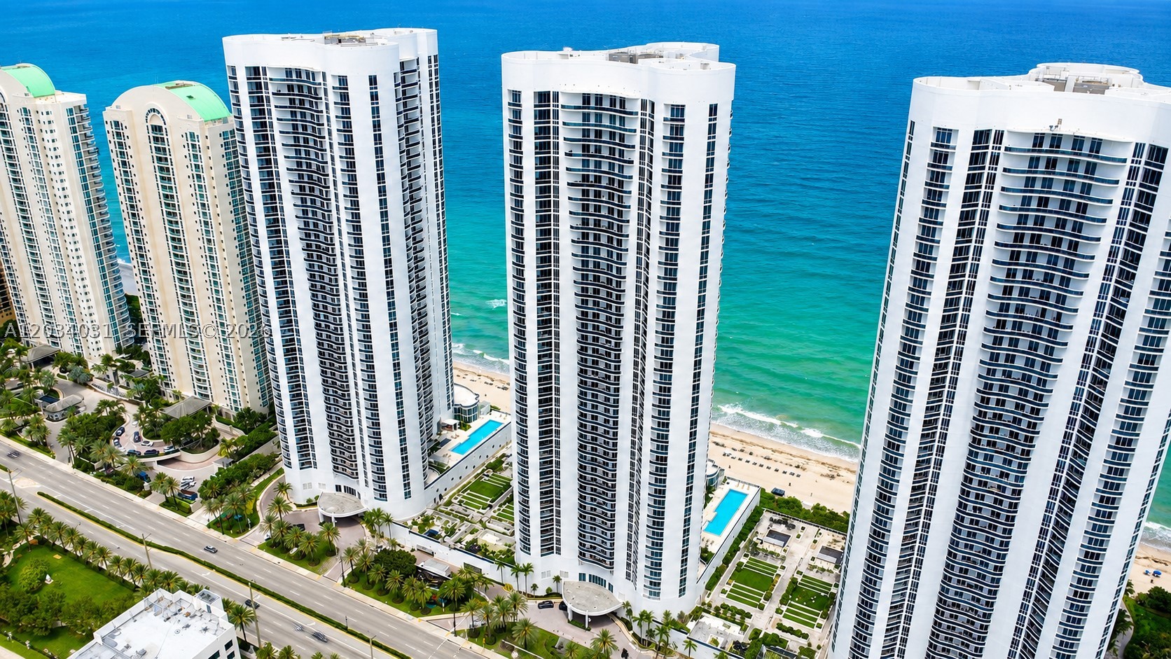 This luxurious two-bedroom, two-bathroom oceanfront lanai condo offers 1,850 square feet of living space, complete with an oversized private terrace that opens directly to the pool deck. With the charm of a beach house, it features a soaring living room ceiling and stunning views through 10-foot floor-to-ceiling windows. The spacious master suite includes its own bathroom, while the modern kitchen is perfect for entertaining. Exclusive beachfront perks include private beach chairs, an oceanfront gourmet restaurant with delivery right to your spot, a lavish clubhouse, a state-of-the-art gym, his and her spas, two lap pools with attendants, valet service for two cars via an on-call app, and a business center. The property also boasts a spectacularly renovated patio and pool area.