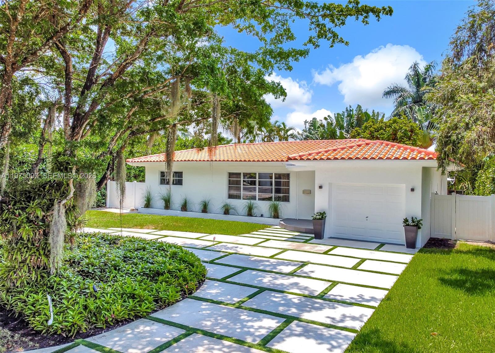 This luminous oasis awaits you in a tranquil neighborhood with friendly neighbors and no through traffic. Inside, an open-concept floor plan is perfect for entertaining, featuring 3 bedrooms and 2 baths. The kitchen is a chef's dream with sleek stainless steel appliances. Enjoy safety, peace and quiet with high-impact windows and doors. Beautiful restored terrazzo floors, recessed lighting, and contemporary interior doors add a touch of modern elegance. Relax in the zen-like backyard garden, complete with a custom awning and outdoor shower. Ample parking is available with a circular driveway and a spacious garage. Don't miss this opportunity to live in a piece of Mid-Century Modern history in a prime Miami Shores location!