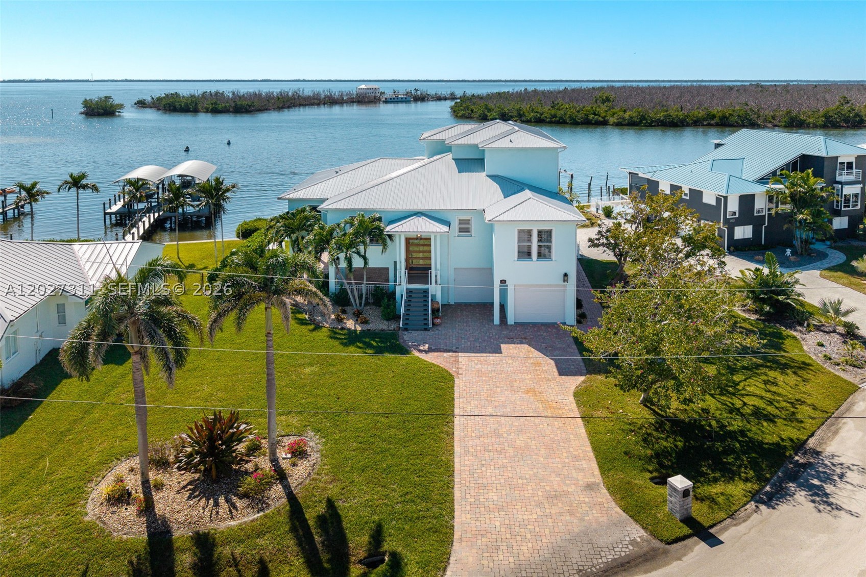 LUXURY LIVING AT ITS BEST IN ST. JAMES CITY! Perfectly positioned on the open waters of San Carlos Bay, this fully renovated waterfront estate offers deep-water Gulf access, unobstructed views, and island charm. Located at the southern tip of Pine Island, the home feels private and serene while remaining close to Cape Coral and Fort Myers. Rare wide bay frontage delivers breathtaking sunsets and endless open-water views, while over $400,000 in renovations provide exceptional quality and peace of mind, including a roof, spray-foam insulation, hurricane-impact windows and doors, whole-home generator, updated HVAC, ductwork, and instant hot water heaters. Boating enthusiasts will appreciate the protected deep-water dock with no bridges and two new boat lifts (6,000 lb. and 15,000 lb.) for effortless Gulf access. Outdoor living shines with a heated pool and spa overlooking the bay, a custom tiki hut, and a fully equipped outdoor kitchen. Inside, refined coastal finishes include wide-plank tile flooring, custom closets, and a chef’s kitchen featuring JennAir appliances, exotic granite countertops, and over $250,000 in custom cabinetry. Offered tastefully furnished in Tommy Bahama style (with exclusions), this turnkey estate also features an oversized four-car garage with epoxy flooring for up to six vehicles plus extra storage. A rare combination of luxury craftsmanship, energy efficiency, security, and true waterfront living in one of Southwest Florida’s most desirable locations.
