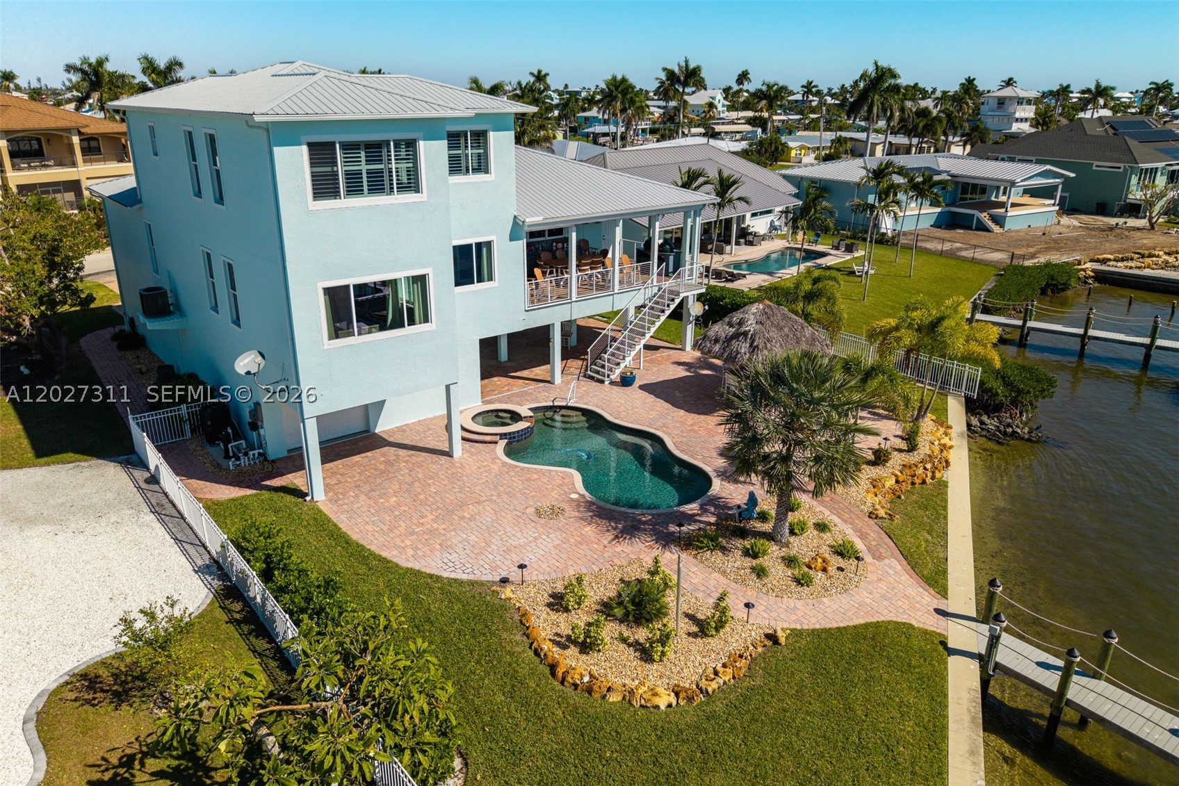 LUXURY LIVING AT ITS BEST IN ST. JAMES CITY! Perfectly positioned on the open waters of San Carlos Bay, this fully renovated waterfront estate offers deep-water Gulf access, unobstructed views, and island charm. Located at the southern tip of Pine Island, the home feels private and serene while remaining close to Cape Coral and Fort Myers. Rare wide bay frontage delivers breathtaking sunsets and endless open-water views, while over $400,000 in renovations provide exceptional quality and peace of mind, including a roof, spray-foam insulation, hurricane-impact windows and doors, whole-home generator, updated HVAC, ductwork, and instant hot water heaters. Boating enthusiasts will appreciate the protected deep-water dock with no bridges and two new boat lifts (6,000 lb. and 15,000 lb.) for effortless Gulf access. Outdoor living shines with a heated pool and spa overlooking the bay, a custom tiki hut, and a fully equipped outdoor kitchen. Inside, refined coastal finishes include wide-plank tile flooring, custom closets, and a chef’s kitchen featuring JennAir appliances, exotic granite countertops, and over $250,000 in custom cabinetry. Offered tastefully furnished in Tommy Bahama style (with exclusions), this turnkey estate also features an oversized four-car garage with epoxy flooring for up to six vehicles plus extra storage. A rare combination of luxury craftsmanship, energy efficiency, security, and true waterfront living in one of Southwest Florida’s most desirable locations.