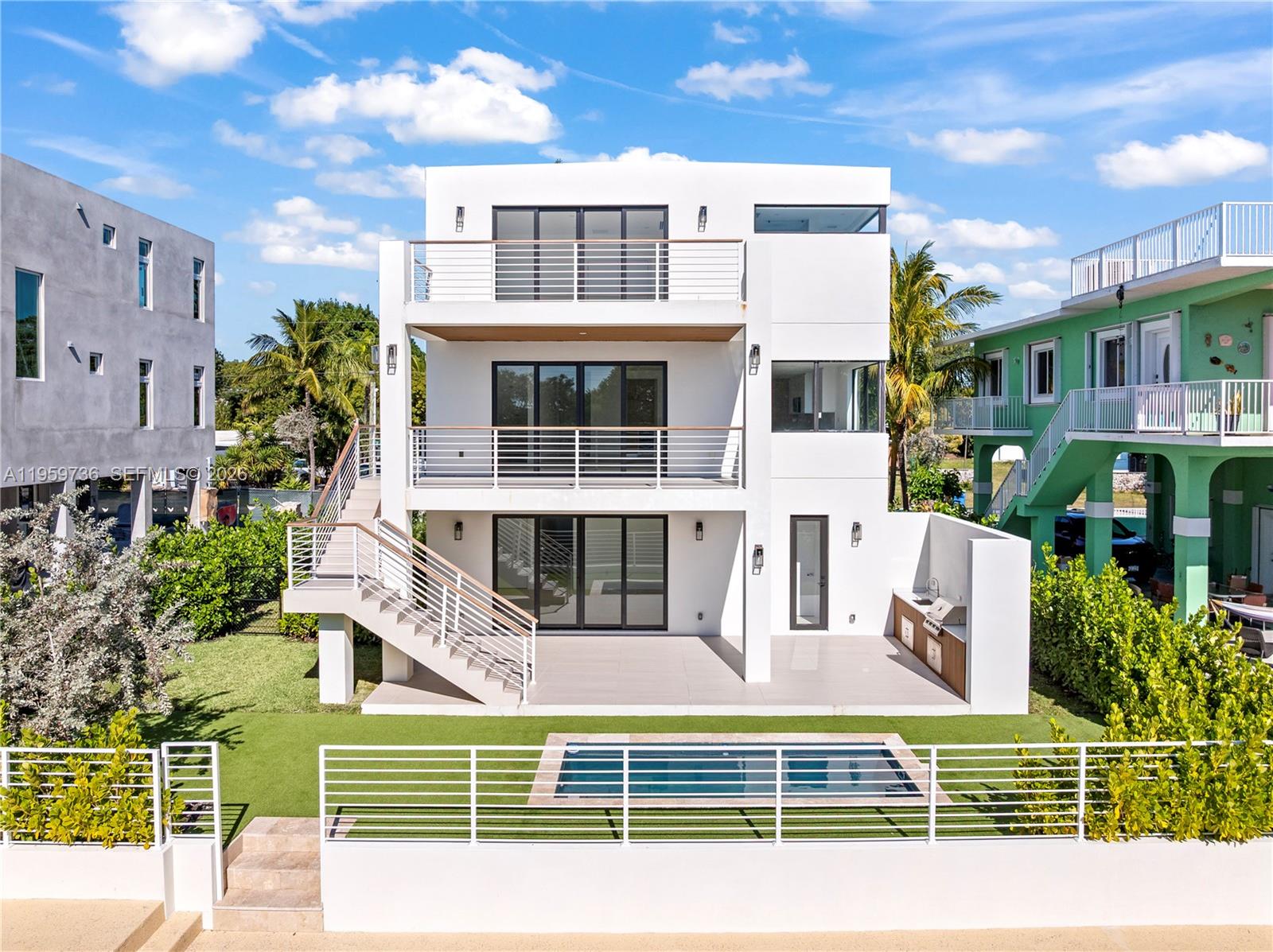 Brand-new contemporary waterfront home in premier Plantation Key with 60 ft of protected deep-water dockage and seawall, offering direct canal access to Tavernier Creek, the Atlantic Ocean, and Florida Bay. Ground level features an open-air two-car garage and spacious covered area. First living level offers a large recreation room opening to the poolside patio with full cabana bath, perfect for entertaining and relaxed island living. Second level boasts a bright open-concept living and dining area and a gourmet chef’s kitchen with Italian cabinetry, premium finishes, and adjacent laundry room with sink and built-ins, all flowing to a covered waterfront terrace for seamless indoor-outdoor living. Third level showcases a luxurious primary suite with walk-in closet, spa-style bath with two-person shower, and private balcony overlooking the water, plus three guest bedrooms and a well-appointed guest bath. Outdoor amenities include a pool, covered terrace, and professional outdoor kitchen for year-round enjoyment. Ideally located in the Upper Florida Keys, close proximity to restaurants, a short boat ride to Tavernier Creek Marina for fuel, ice, and snacks, and minutes to boutiques, breweries, and 5-star dining in Islamorada—a rare blend of modern luxury and the ultimate Florida Keys waterfront lifestyle.