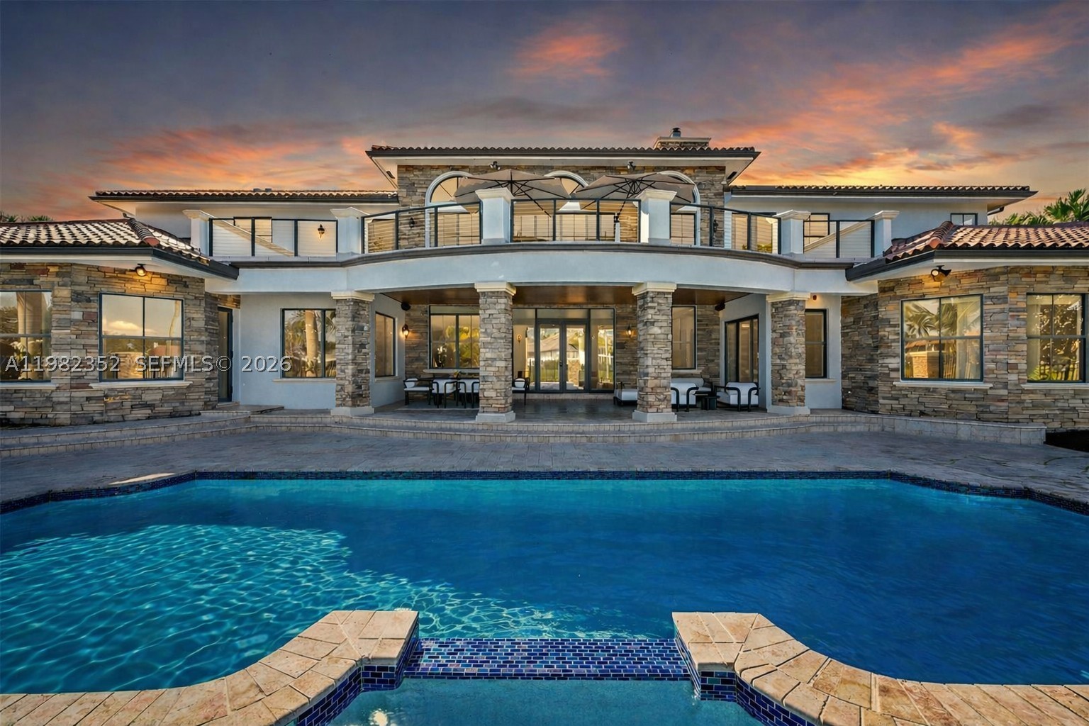 Weston’s premier trophy estate, set on a coveted corner lot with exceptionally rare and expansive waterfrontage in the prestigious guard-gated community of Windmill Ranch. Exquisitely remodeled with impeccable craftsmanship and refined finishes, this magnificent residence offers approximately 8,400 square feet of elegant living space with five bedrooms, six full baths, two half baths, plus a formal office and media room. Features include an elevator, impact windows and doors, and a four-car garage. A breathtaking resort-style pool and private spa overlook sweeping lake vistas, while the stunning primary suite enjoys some of the most spectacular views in all of Weston. With no neighbor to the west, the estate offers exceptional privacy. A truly rare and remarkable offering in one of Broward County’s most prestigious communities.