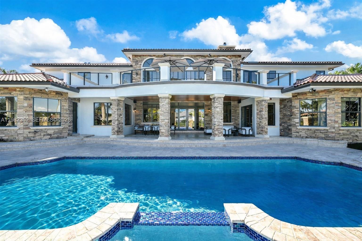 Weston’s premier trophy estate, set on a coveted corner lot with exceptionally rare and expansive waterfrontage in the prestigious guard-gated community of Windmill Ranch. Exquisitely remodeled with impeccable craftsmanship and refined finishes, this magnificent residence offers approximately 8,400 square feet of elegant living space with five bedrooms, six full baths, two half baths, plus a formal office and media room. Features include an elevator, impact windows and doors, and a four-car garage. A breathtaking resort-style pool and private spa overlook sweeping lake vistas, while the stunning primary suite enjoys some of the most spectacular views in all of Weston. With no neighbor to the west, the estate offers exceptional privacy. A truly rare and remarkable offering in one of Broward County’s most prestigious communities.
