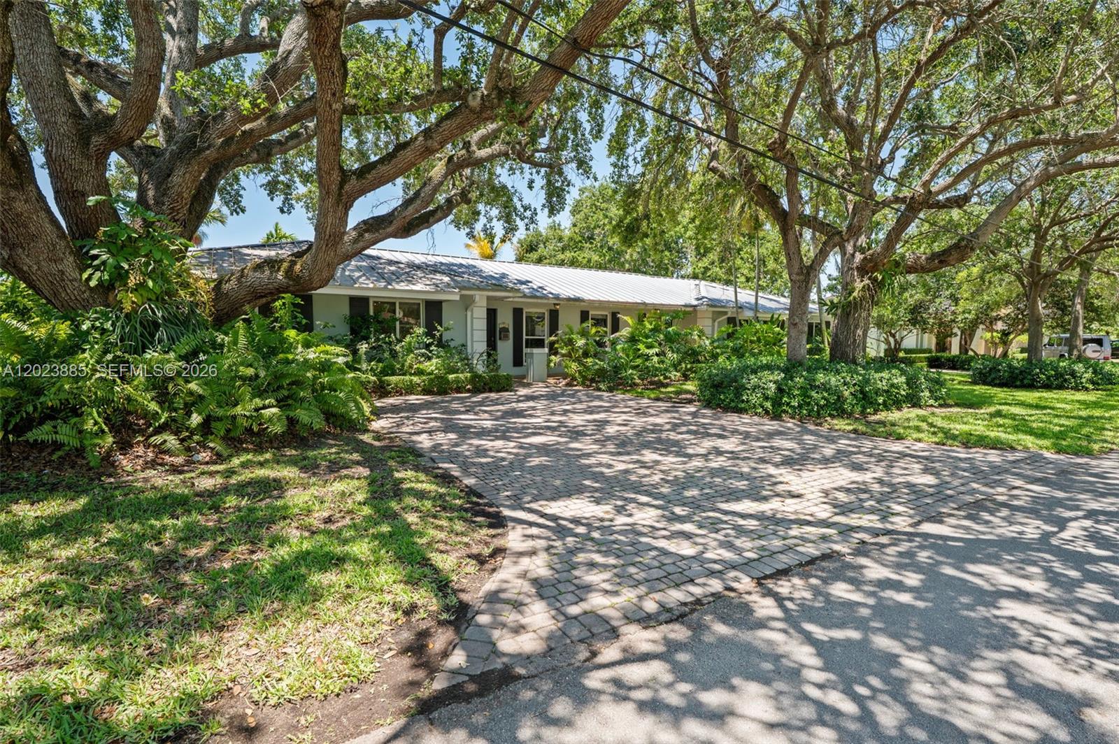 Beautifully appointed 5-bedroom, 2.5-bath pool home in sought-after Pinecrest, offering a spacious and inviting layout designed for comfortable family living and effortless entertaining. This residence features elegant stone and wood flooring throughout, abundant natural light, and an open floor plan with French doors overlooking a covered patio, sparkling pool, and beautifully landscaped backyard creating a true indoor-outdoor lifestyle. The thoughtfully designed layout features 4 bedrooms and 2.5 bathrooms on one side of the home, while a huge 5th bedroom on the opposite wing offers endless possibilities as a guest suite, home office, gym, playroom, or flex space. Enjoy a formal living room, separate dining room, family room with built-in wet bar, and an eat-in kitchen with stainless steel appliances, creating comfortable spaces for both everyday living and entertaining.
The spacious primary suite includes a dressing area, three walk-in closets, dual sinks, soaking tub, separate shower, and direct pool access. Step outside to your private backyard oasis featuring a sparkling pool, lush landscaping, canal access, and a great tree house. Additional highlights include a metal roof, full impact windows and doors, and highly desirable Palmetto school boundaries.