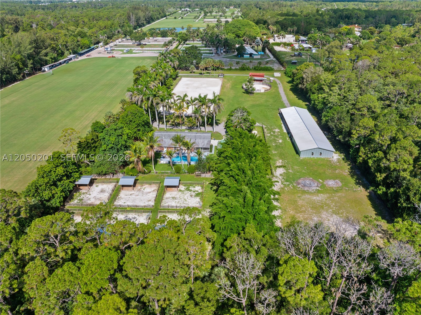 An exceptional opportunity to own a private five-acre equestrian estate just 15 minutes from the Wellington International show grounds. Thoughtfully designed for both immediate use and future expansion, the property is centered around a professionally positioned 115' x 246' riding arena and a newly constructed 12-stall center-aisle barn. The barn was designed with expansion in mind and includes a 40' x 50' enclosed area that can easily be converted into six additional 12' x 12' stalls, creating an 18-stall facility. Equestrian amenities include six spacious paddocks, each with its own run-in shed, a round pen, four wash/tack stalls, a dedicated tack room, and a comfortable one-bedroom apartment ideal for staff, guests, or a trainer. Complementing the equestrian improvements is a beautifully maintained residence featuring over 3,100 square feet of living space, a screened saltwater pool, and a gated, private setting surrounded by mature landscaping. Whether you're seeking a turnkey training facility, a private equestrian retreat, or a property with the infrastructure to create a premier boarding operation, this farm offers endless potential in one of Palm Beach County's most sought-after equestrian locations.