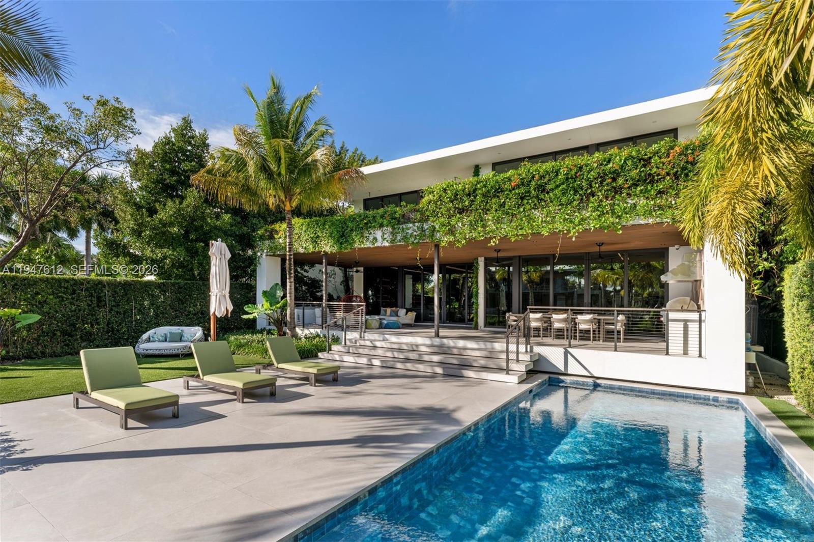 Welcome to 7333 Belle Meade Blvd, an exquisite tropical-modern sanctuary masterfully curated by 2id Interiors. Set on an 11,528 SF waterfront lot with 71’ of frontage, this residence embraces warm modern materials and sculptural lines to offer the ultimate Miami lifestyle.

Bathed in natural light, the interior features 10’ ceilings and floor-to-ceiling windows framing serene water views. Elegant custom wood paneling, large Italian porcelain flooring, and a spectacular floating staircase set a refined tone. The Mia Cucina chef’s kitchen is a statement in functionality, equipped with Wolf/Sub-Zero appliances, a wine cooler, expansive island, and a fully outfitted butler’s pantry. The open layout flows seamlessly to an oversized covered terrace and BBQ pavilion for elevated entertaining.

The home offers 5 spacious bedrooms plus a lofted studio office, with three bedrooms enjoying private waterfront balconies. The primary suite is a true retreat featuring a spa-style bath with a soaking tub, steam shower, and sauna. A top-tier media room with beverage center and a home gym complete the luxury experience.

Outside, the property transforms into a private resort with a sparkling pool, lush landscaping, and a 60’ dock offering effortless bay access. Features include a 2-car garage, laundry w/ steam dryer, smart home integration, and 24-hour guard-gated security. A masterwork of elegance and innovation, this is the epitome of Miami modern living.