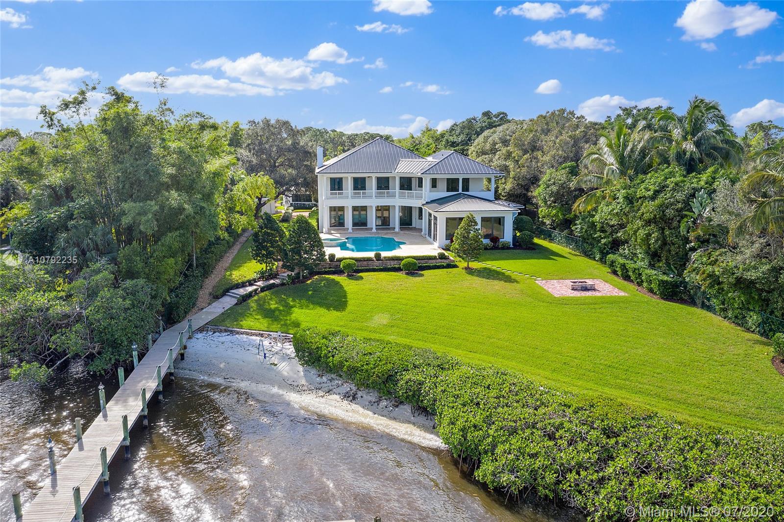 Magnificent Pennock Point grand private estate located on the Loxahatchee River with 144 ft. of frontage. Gated entry with long Chicago Brick driveway lead to this unique 1.72 acre compound. This Architecturally elegant plantation style home features 4 bedrooms with 4789 sf living area in main house + a 2 bedroom guesthouse, an au pair suite above the garage and separate fitness room. Detailed finishes throughout include Impact glass, French doors, Bamboo floors, Crown Molding, Formal living room with fireplace and waterfront views , Dining room with a temperate controlled wine room. Light and bright Gourmet kitchen features Chefs Island w/sink, Subzero refrigerator & Viking appliances. Office with wet bar & family room with stunning waterfront views overlooking a resort style pool & spa.