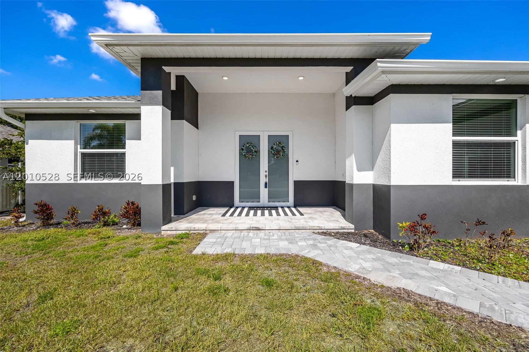 Just like new and ideally positioned in one of Cape Coral’s most desirable communities near Coral Lakes Golf Course, this luxury pool home offers a perfect blend of privacy, modern design, and Southwest Florida living. Surrounded by beautifully maintained estate homes, some backing to the golf course, the property makes a strong impression with its inviting entry, modern lighting, and elegant double doors. Inside, a spacious open floorplan with great room design is ideal for entertaining, with expansive sliders from the living and dining areas creating seamless indoor-outdoor flow to the lanai and pool. The custom kitchen features a striking waterfall countertop, upgraded finishes, and a clean, modern look. The primary suite offers generous space, a large walk-in closet, and a spa-like bath, while the split-bedroom layout provides privacy for guests with two bedrooms in their own wing. A versatile den with double doors works perfectly as a home office, flex space, or potential fourth bedroom. Outside, enjoy an oversized lanai with a custom pool and spa, plus a full outdoor kitchen with built-in grill, burner, sink, and mini fridge. The expansive patio overlooks a peaceful wooded backdrop owned by the City for the golf course, adding privacy and natural views. With impact windows and doors, energy efficiency, and a prime location on one of the community’s best streets just a short walk to golf, this home truly checks every box for Florida luxury​​‌​​​​‌​‌​​​‌‌​​​‌‌‌​​‌​​‌‌​​​​ living.