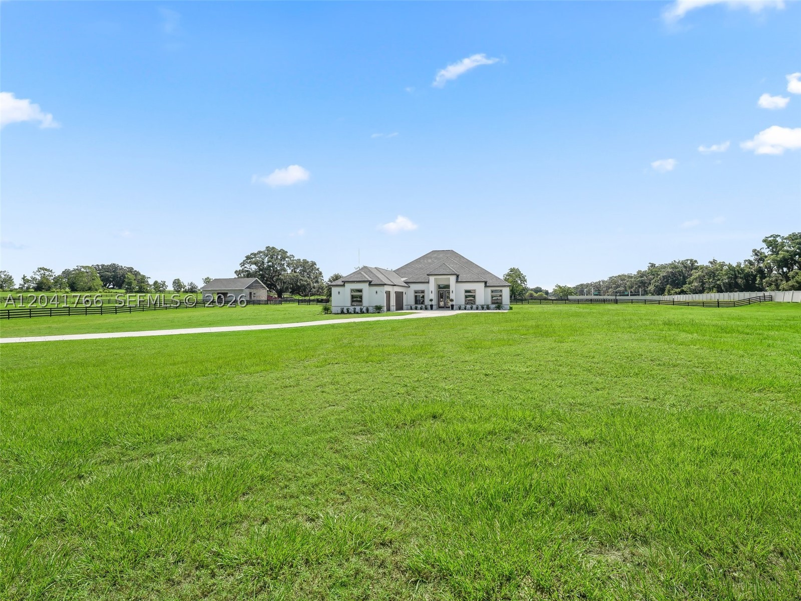 Welcome Home —A brand-new, custom-built estate gracefully situated on one of the largest parcels within the exclusive, gated community of SummerHill. Tucked behind a private, solar-powered gate, this elegant 4-bed/3-bath home with a dedicated OFFICE. Including A 14-foot wide custom concrete driveway, expanding to 17 feet from post to post, effortlessly accommodates trucks and trailers, while the upgraded 8-foot garage doors add to the home's grand approach. Inside, soaring 13+ foot ceilings and oversized windows flood the living spaces with natural light and picturesque views. Built with insulated concrete block construction and a high-efficiency HVAC system, the home offers exceptional energy savings and year-round comfort. The estate features a stunning 6-stall Saratoga-style barn crafted with imported bamboo, complete with automatic waterers, wash stalls, and two fully fenced paddocks—perfect for equestrian enthusiasts. Highlights include a hardwired CCTV security system for peace of mind, newly designed landscaping accented by solar lighting and upgraded gutters, and two 50 AMP hookups ready for a generator. The property is backed by a one-year builder’s warranty from the date the Certificate of Occupancy was issued. Ideally located just minutes from Ocala’s premier equestrian venues, golf courses, and lifestyle amenities, this home offers a rare opportunity to experience living in one of Central Florida’s most coveted locations.*QUARTZ Coming soon & Kitchen hardware!