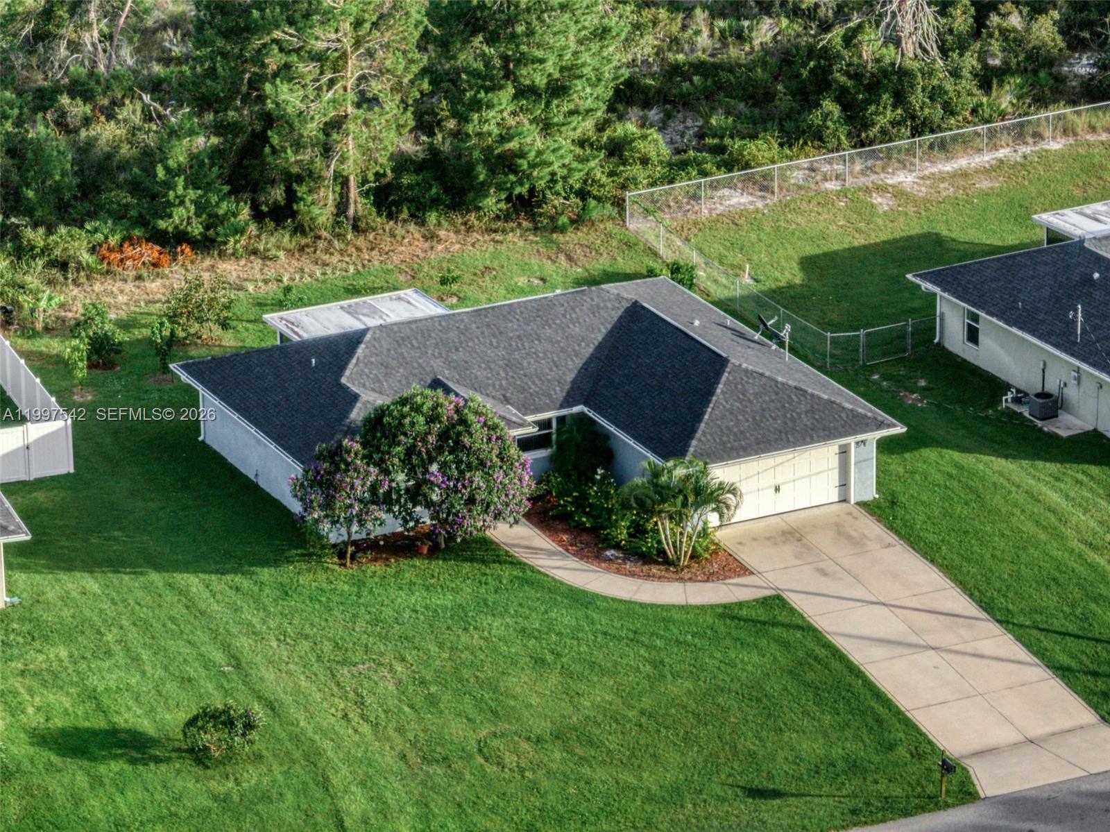 Welcome home to this beautiful 3 bedroom, 2 bath home located in the heart of Lake Placid, your own slice of Florida paradise. This inviting home features an open layout perfect for everyday living or entertaining guests. The kitchen offers granite countertops, a spacious island, and stainless steel appliances. The primary suite includes a large walk in closet and dual sinks. Additional features include a 2 car garage and an extended paved driveway providing plenty of parking. Step outside and enjoy a covered terrace surrounded by avocado, mango, orange, and persimmon trees, creating a private backyard oasis. Conveniently located close to Lake Placid’s shops, restaurants, lakes, and more.