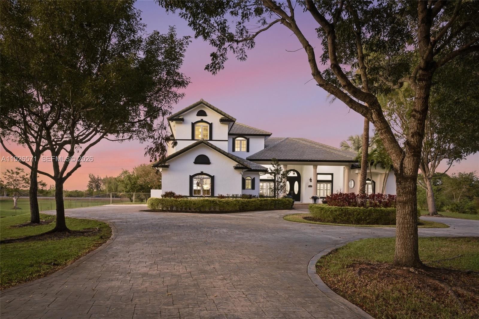 A rare luxury offering in prestigious Southwest Ranches, this custom-built estate delivers privacy, serenity, and refined living on an expansive 1.2-acre cul-de-sac waterfront lot with no neighbors behind. Designed for discerning families who value space, nature, and effortless convenience, the property sits moments from major roads, upscale shopping, dining, and top-tier amenities—yet feels worlds away.

The split 5-bedroom, 4-bath layout is anchored by a grand primary suite and complemented by one additional flexible room ideal for a private office, gym, studio, or conversion into extra bedrooms. Soaring 12-foot ceilings elevate the ambiance across the elegant family room, breakfast area, and chef’s kitchen appointed with wood cabinetry, granite countertops, stainless steel appliances, an LG refrigerator, a Bosch double wall oven, and a generous island.

Outdoor living unfolds like a private resort. Enjoy a screened heated pool and jacuzzi, a spacious gazebo with full bar, and lush grounds enhanced by mature mango, avocado, and other fruit trees—a true sanctuary for those who appreciate nature and open space. Impact doors and windows provide peace of mind, while NO HOA ensures unmatched freedom and flexibility.

Recent price adjustment positions this home as a strong value in Southwest Ranches, offering generous square footage and exceptional livable space.