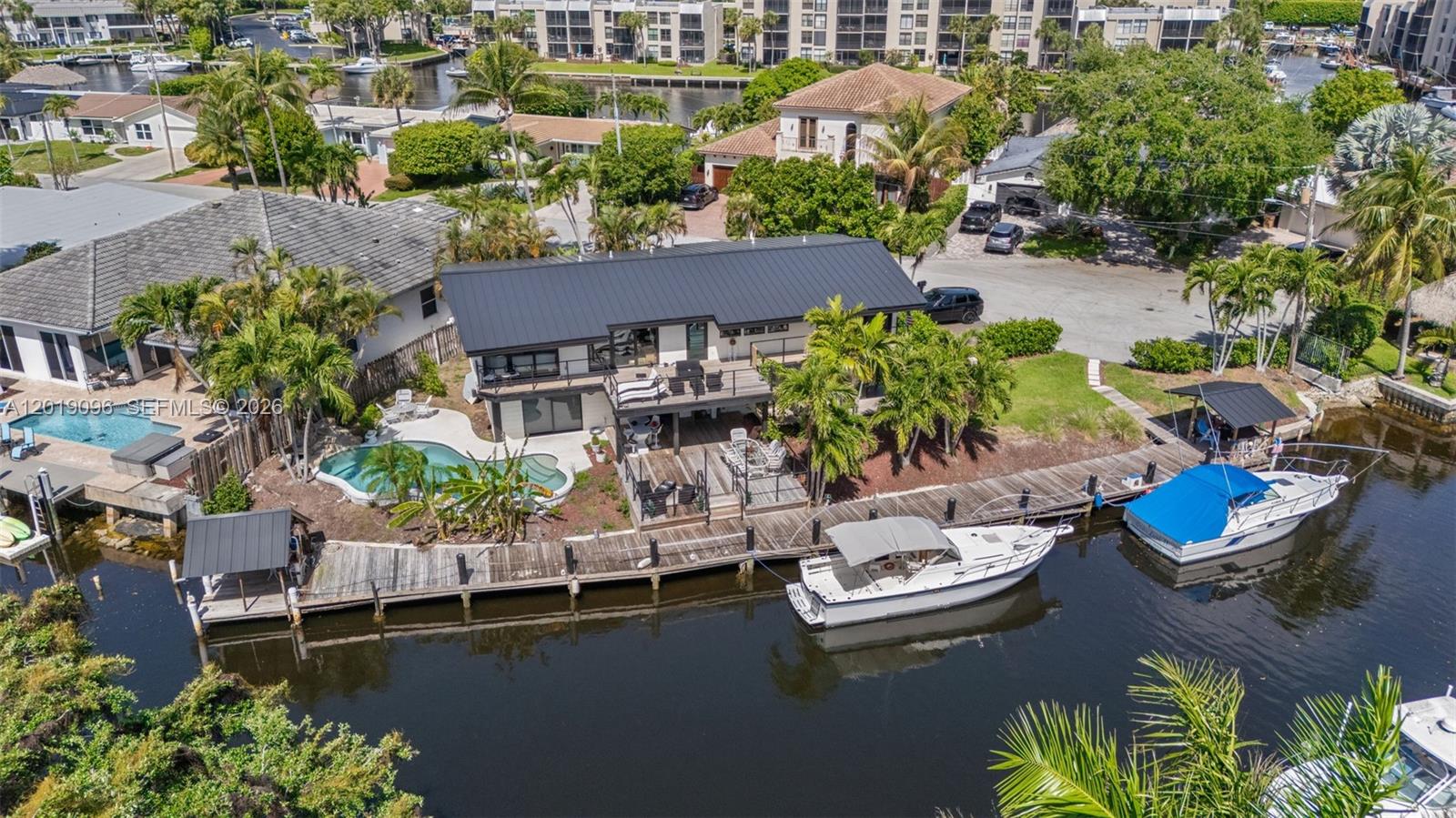 Experience the ultimate South Florida waterfront lifestyle in this remodeled 5-bedroom, 4.5-bath pool home featuring 170 feet of water frontage and endless opportunities for outdoor entertaining. Whether you are relaxing by the pool, hosting sunset gatherings, or setting out on your boat from the private 130-foot dock, this residence captures the very best of coastal living. Designed with comfort and flexibility in mind, the unique split floor plan offers a spacious upstairs layout with three bedrooms and two and a half baths, including a primary suite with a private balcony, walk-in closet, and spa-inspired bath. Downstairs, two guest units and a vibrant living area provide the perfect setting for visitors or a short-term rental investment. Every detail has been thoughtfully updated, from the new roof and impact windows to the upgraded deck and finishes throughout. Whether you are searching for a glamorous vacation retreat, a short term rental opportunity, or a place to call home, you will find style and functionality woven seamlessly together. Just minutes from Deerfield Beach, the pier, parks, shopping, and dining, this property offers a blend of luxury, leisure, and location that is hard to match. Do not miss the chance to own your slice of paradise where every day feels like a getaway.