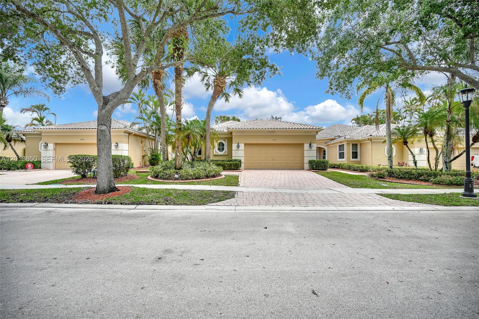 Exceptional residence in the highly sought-after Bay Isle at Weston Hills Country Club, a premier golf community. Double glass entry doors open to sweeping golf course and lake views. This custom-upgraded home features soaring ceilings, crown molding, recessed lighting, and plantation shutters throughout. Expansive living and dining areas are finished with elegant marble flooring. The oversized primary suite offers serene golf views and generous custom walk-in closets. A gourmet kitchen is appointed with top-of-the-line stainless steel appliances, double wall ovens, wine cooler, granite countertops, and a center island. Enjoy outdoor living from the large screened patio. HOA includes exterior paint, pressure cleaning, and lawn maintenance for a true low-maintenance lifestyle.