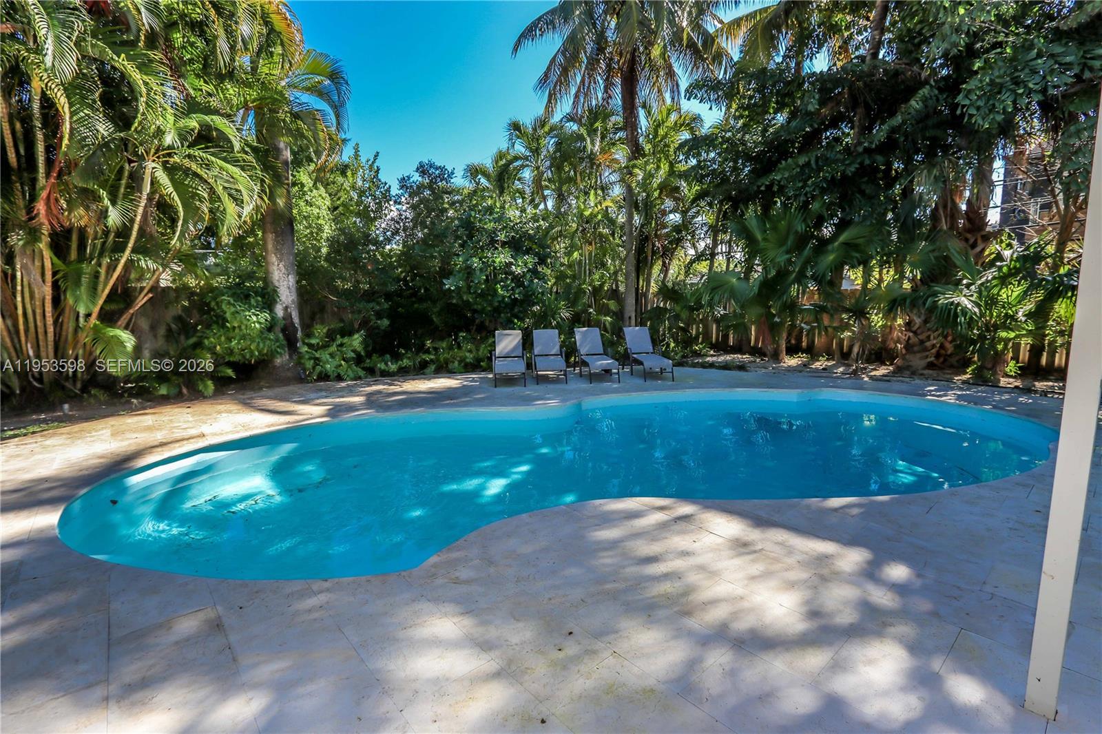 Located in the highly sought-after Hollywood Lakes neighborhood, this beautifully maintained 3-bedroom, 3-bath pool home sits on a rare double lot, offering an exceptional blend of space, comfort, and South Florida lifestyle. The home features a bright, open floor plan with wood flooring and crown molding throughout, creating a warm and inviting atmosphere. A separate den with French doors provides flexible living space ideal for a home office, media room, or guest area.

The kitchen is thoughtfully designed with stainless steel appliances, an oversized refrigerator, and seamless flow into the spacious family room. Expansive windows and  double French doors frame tranquil views of the pool and open fully to the outdoor deck, allowing for effortless indoor-outdoor living and entertaining.
A circular driveway provides ample parking, while the private backyard offers a true tropical retreat with a resort-style pool and expansive deck, ideal for entertaining or enjoying peaceful outdoor living.

This energy-efficient home includes all hurricane impact windows, a 3-year-old metal roof, solar panels, a new pool pump, and new pool deck and pavers completed in 2025. Ideally situated just blocks from Hollywood’s main shops, minutes from the beach, and only two blocks from the golf club, the location is truly unbeatable.