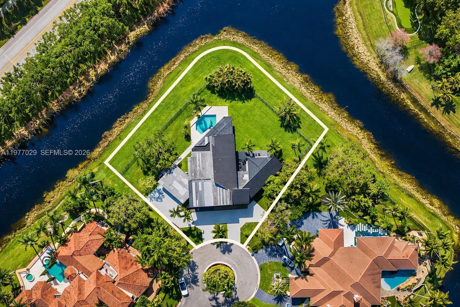 Rare offering in Windmill Ranch Estates featuring one of the largest waterfront cul-de-sac point lots currently available in the community. This exceptional property sits on a private 44,219 SF acre-plus lot with water views on both sides and remarkable privacy.
The unique contemporary residence offers 5 bedrooms, 5.5 bathrooms, and a private office that can easily serve as a sixth bedroom. The home showcases dramatic 28-foot ceilings, expansive glass walls, and a striking architectural design filled with natural light.
Architectural highlights include a spectacular two-story library with a spiral staircase, a grand sweeping staircase, spacious living areas, and a gourmet kitchen with quartz countertops and stainless steel appliances.
The primary suite features dual bathrooms and oversized walk-in closets. Outdoor spaces include a pool, multiple terraces, and a summer kitchen, ideal for entertaining while enjoying beautiful sunset and water views.