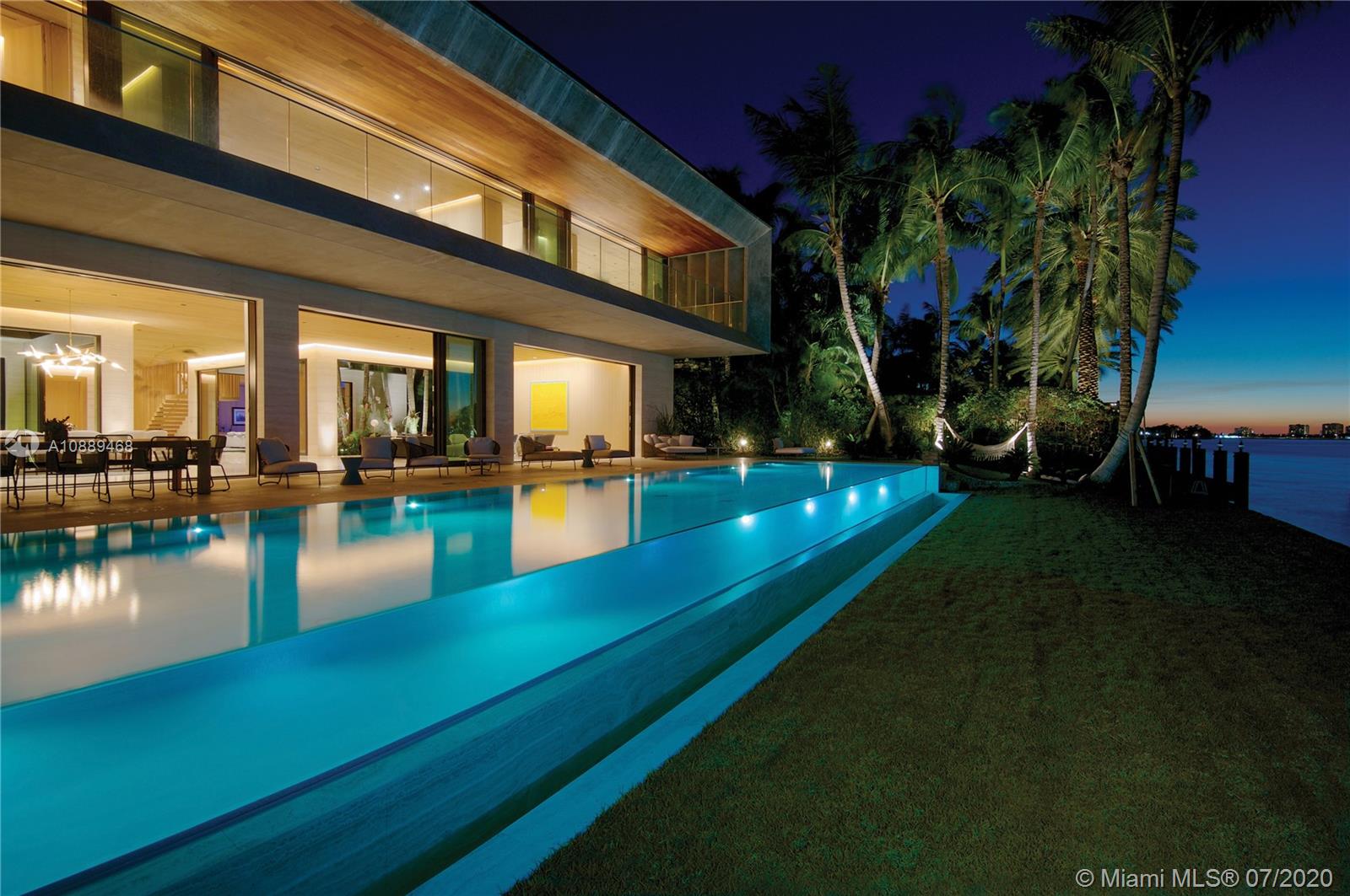 The ultimate subtropical modern oasis, this museum-quality residence was crafted in 2016 by award-winning
architect Chad Oppenheim in the Village of Bal Harbour, one of the most private and secure communities in Miami.
The waterfront estate was masterfully designed to seamlessly blur the lines of indoor-outdoor living with over 13,500 square feet of living space on three levels, including a decadent 2,000 square-foot master suite and a spectacular roof deck with jacuzzi and bar. The home boasts Roman Travertine and Belgian Oak throughout. The 75' X 17' infinity-edge glass pool is the largest in Miami. Experience spectacular water and sunset views from the home’s unique vantage point just 300 yards from one of only two inlets in Miami Beach, where the Atlantic Ocean meets Biscayne Bay.