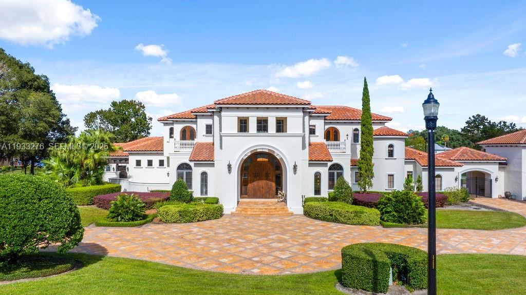 Experience exceptional lakefront living in this one-of-a-kind estate located on a double lot within the prestigious guard-gated community of Lake Markham Preserve, just minutes from Lake Mary, Longwood, and Heathrow. This elegant residence offers 5 bedrooms, 7 bathrooms, and a 6-car garage, set on over two acres of private, manicured grounds.
A grand two-story foyer welcomes you with a sweeping double staircase, soaring ceilings, and stunning views of the infinity-edge pool blending into the lake. The primary wing is a private wellness retreat featuring sea-salt walls and a dedicated salt therapy room, along with a sauna, massage room, private gym, and spa-inspired bath. The primary suite and executive office open to a serene Tuscan-style courtyard.
The gourmet kitchen flows into expansive living and entertainment areas, including a game room with a private bowling lane. Upstairs, enjoy three en-suite bedrooms, a theater room, and a large balcony overlooking the pool and Lake Markham. Outdoor living includes a heated infinity pool and spa, summer kitchen, tiki cabana, sports courts, and a private dock with covered lift. A detached guest house, wine cellar, generator, and circular driveway complete this extraordinary estate.