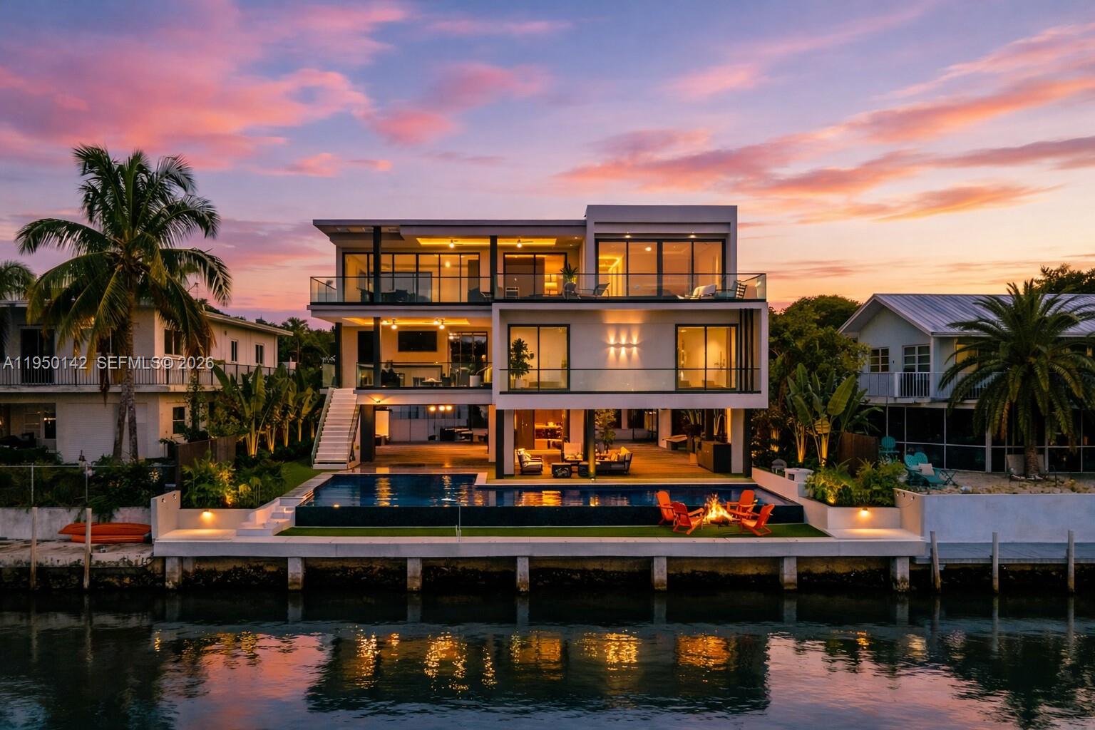 Waterfront luxury in the heart of Key Largo, Florida. This newly constructed home combines modern opulence and an unmatched location. Tastefully designed for island living, the property boasts an array of high-end finishes and a thoughtfully curated layout. The main level of the home features 4 bedrooms and 4 and a half bathrooms along with a sprawling covered patio and plentiful entertainment space. Upstairs, you’ll find the primary suite, kitchen, great room, and additional porch space to embrace true indoor-outdoor Keys living. Relax and entertain in style with a private infinity-edge lap pool and luxurious champagne spa, perfect for unwinding after a day on the water. Your boats are ready to be docked at the newly installed 70-foot concrete seawall and dock, making this an ideal retreat for boating enthusiasts. Additional highlights include Miele kitchen appliances, nine-foot impact glass windows and doors, a solar panel system, full audio throughout all rooms and outdoor spaces, a CCTV camera security system, an outdoor summer kitchen, a putting green and much more.