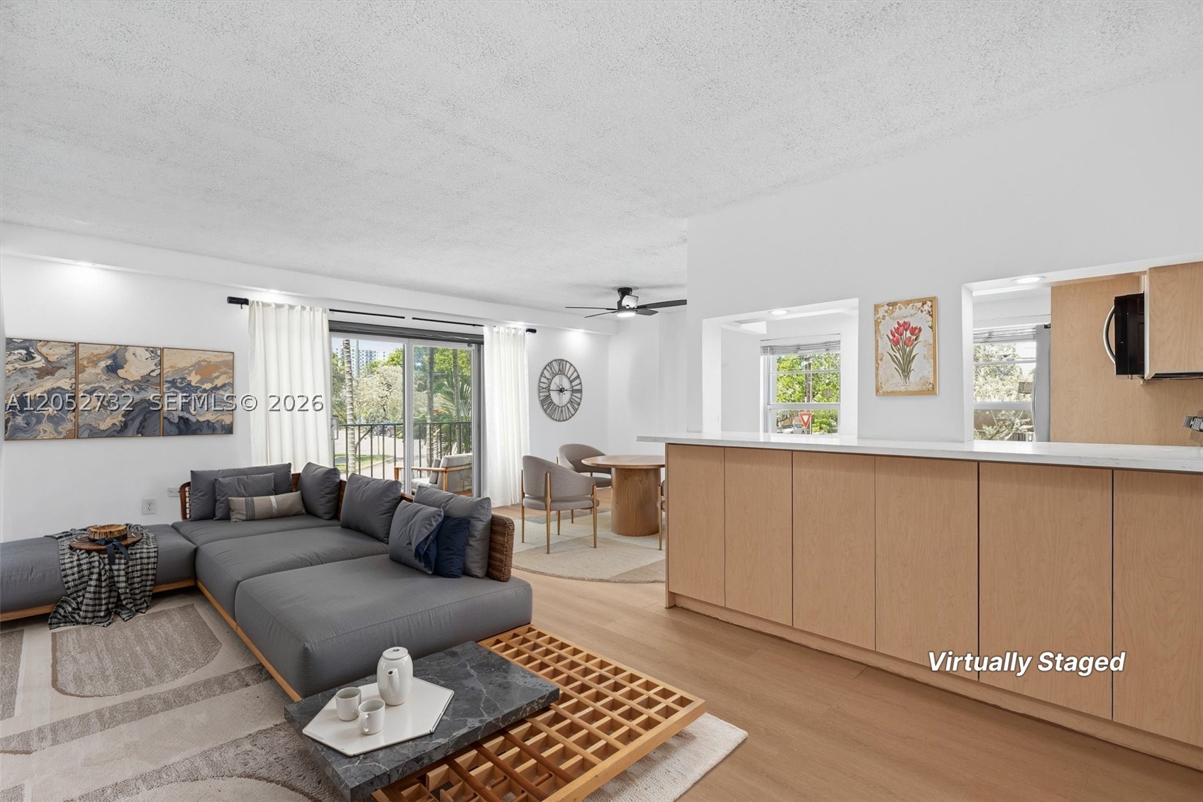 Perfectly positioned in the boutique Ionian Plaza Condominiums, this beautiful corner residence offers the ideal blend of comfort, convenience, and South Florida's vibrant lifestyle. Begin your day surrounded by abundant Florida sunshine streaming through oversized windows, then enjoy coffee on your private balcony before heading out to explore the nearby beaches, dining, shopping, and entertainment, all just minutes away. Inside, the second-floor condo features an open, airy layout with stylish vinyl plank flooring throughout. The thoughtfully designed kitchen is ideal for both everyday living and entertaining, offering white Corian countertops, stainless steel appliances, bar-height seating, and space for casual dining. Spacious bedrooms provide exceptional storage with oversized closets, while the updated bathrooms add a fresh, modern touch. The generous primary suite easily accommodates a work-from-home office, and the convenience of an in-unit washer and dryer makes daily living effortless. Residents enjoy the benefits of an elevator building, assigned parking, a community pool, bike storage, and expansive balcony access from both the living room and bedrooms, creating the perfect setting to embrace South Florida living.