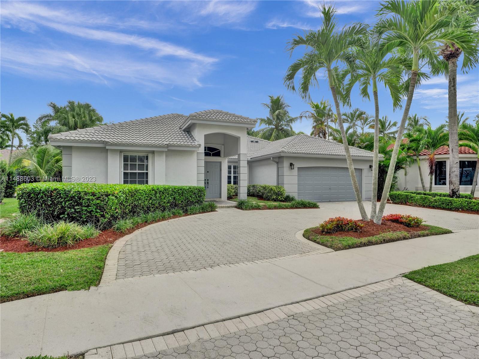 Welcome to your dream home in Jardin, one of Weston Hills Country Club's most coveted neighborhoods! This spacious "Covington Five" floor plan boasts a triple split floor plan with 4 bedrooms, 3 1/2 baths plus a den/office. Numerous features include: Grand circular paver driveway, New Roof, foyer entry, volume ceilings through out, Primary bedroom with sitting area & two walk-in closets, formal living & dining rooms, and a gourmet kitchen with granite countertops & wood cabinets. All together with a large covered patio & accordion hurricane shutters. The Jardin neighborhood offers its own park with a Tot Lot, Full Sized Basketball Court, Pickleball Court, & Gazebo Area. Also, the property is excellently located near top rated A+ schools, restaurants, major highways, & hospitals! Must See!