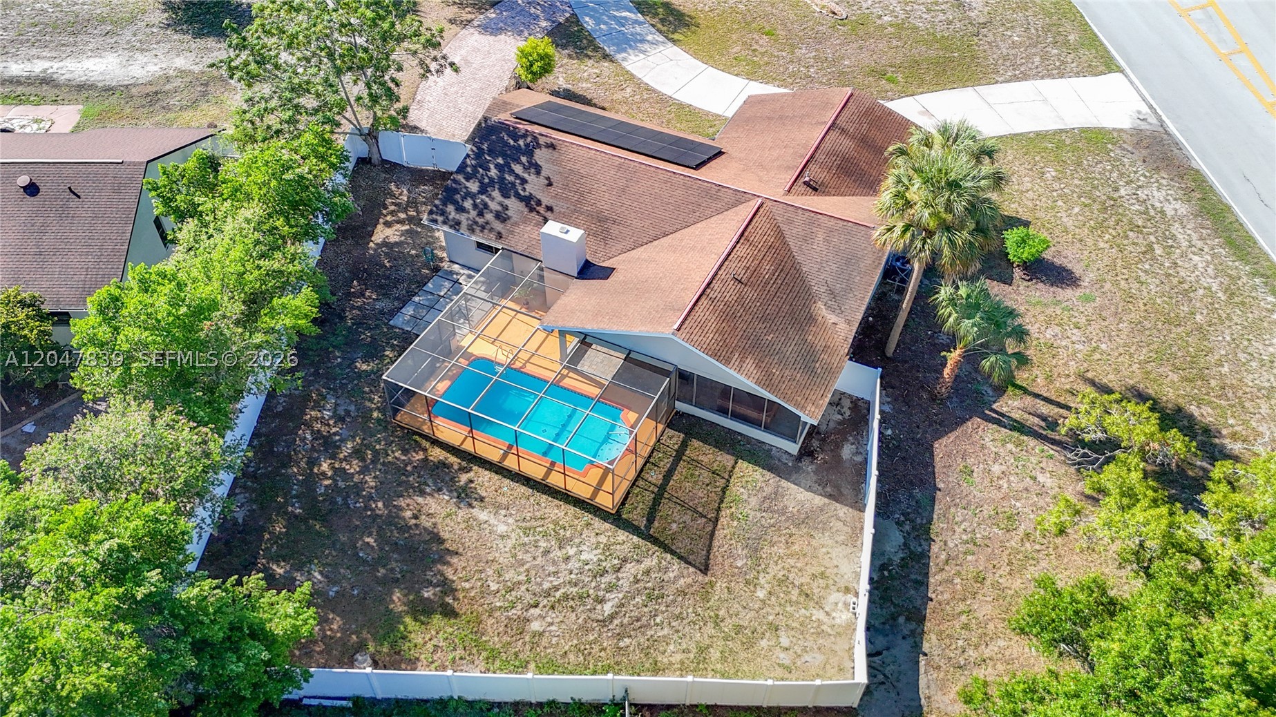 Welcome to your own private Florida retreat! Situated on a spacious corner lot, this beautifully maintained 3-bedroom, 2-bath home offers 1,944 sq. ft. of thoughtfully designed living space where comfort, privacy, and everyday luxury come together.

From the moment you arrive, you’ll appreciate the circular driveway, oversized front yard, decorative paver accents, and 2-car garage. Inside, vaulted ceilings create an open, airy feel, while a stunning floor-to-ceiling stone fireplace adds warmth and character rarely found in today’s homes.

The open kitchen flows into the living area and overlooks the screen-enclosed pool, ideal for entertaining and daily living. The primary suite features a soaking tub, separate shower, and a spacious layout designed for comfort.

Step outside to a covered lanai and private pool area, creating a peaceful outdoor retreat perfect for relaxing or hosting gatherings. The fully fenced backyard and mature landscaping enhance both privacy and charm.

This home also includes fully paid-off solar panels, providing long-term energy savings with no lease or loan, plus a low HOA fee of only $10 per month.

Conveniently located near shopping, schools, dining, and major roads, this move-in-ready home offers the perfect blend of comfort, efficiency, and location.