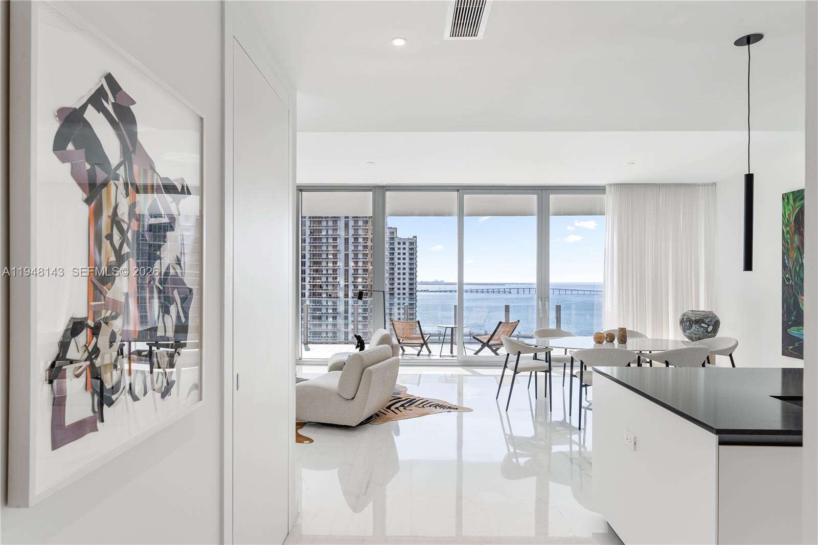 Welcome to Residence 2102 — the most sought-after floor plan at Aston Martin Residences. This turnkey, flow-through residence offers the best of both worlds from its expansive private terrace boasting unobstructed turquoise bay views paired with a sweeping panorama of the Brickell skyline. The home features a dual private elevator foyer leading into an expansive open great room overlooking the bay with 10ft, floor-to-ceiling glass that capture uninterrupted water views & provide exceptional natural light throughout. 3 en-suite bedrooms complete with custom designer closets & window treatments are thoughtfully separated by an elegant gallery creating both privacy and a balanced layout. Finishes are among the finest in Miami: an open chef’s kitchen with custom Bulthaup cabinetry and top-of-the-line Gaggenau appliances is complemented by solid-core Bertolotto doors and imported Thassos marble flooring from Greece. Residents enjoy a five-star living experience with an unparalleled collection of world-class amenities including a private beach club, a house car service, and 4 full floors of sky amenities: indoor & outdoor pools, men’s & women’s spa facilities, a two-story fitness center, and a golf lounge.  Aston Martin Residences is situated within walking distance of many of Miami’s most established dining destinations, everyday conveniences including Whole Foods, and shopping at Brickell City Centre. The Design District & airport are also conveniently just 15 minutes away.