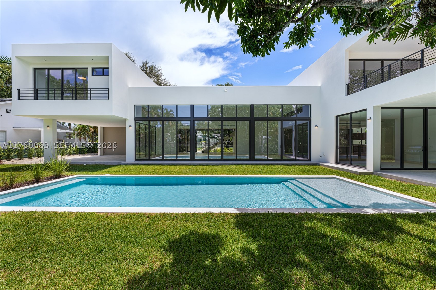 Step into this stunning residence on an oversized lot where elegance meets modern design. A grand entrance with solid core doors leads to Pedini cabinetry, porcelain countertops, and a chef’s kitchen with Miele appliances. The spacious great room features high ceilings and large impact-resistant doors and windows, flooding the home with natural light and showcasing the outdoor retreat with two covered terraces and pool. Upstairs offers three en-suite bedrooms, a secondary laundry, and a luxurious primary suite with private terrace, oversized closet, and spa-like bath. Closets and vanities by Pedini Miami. Elevator-ready and future-ready for a smart home system. Move-in ready with CO in hand.