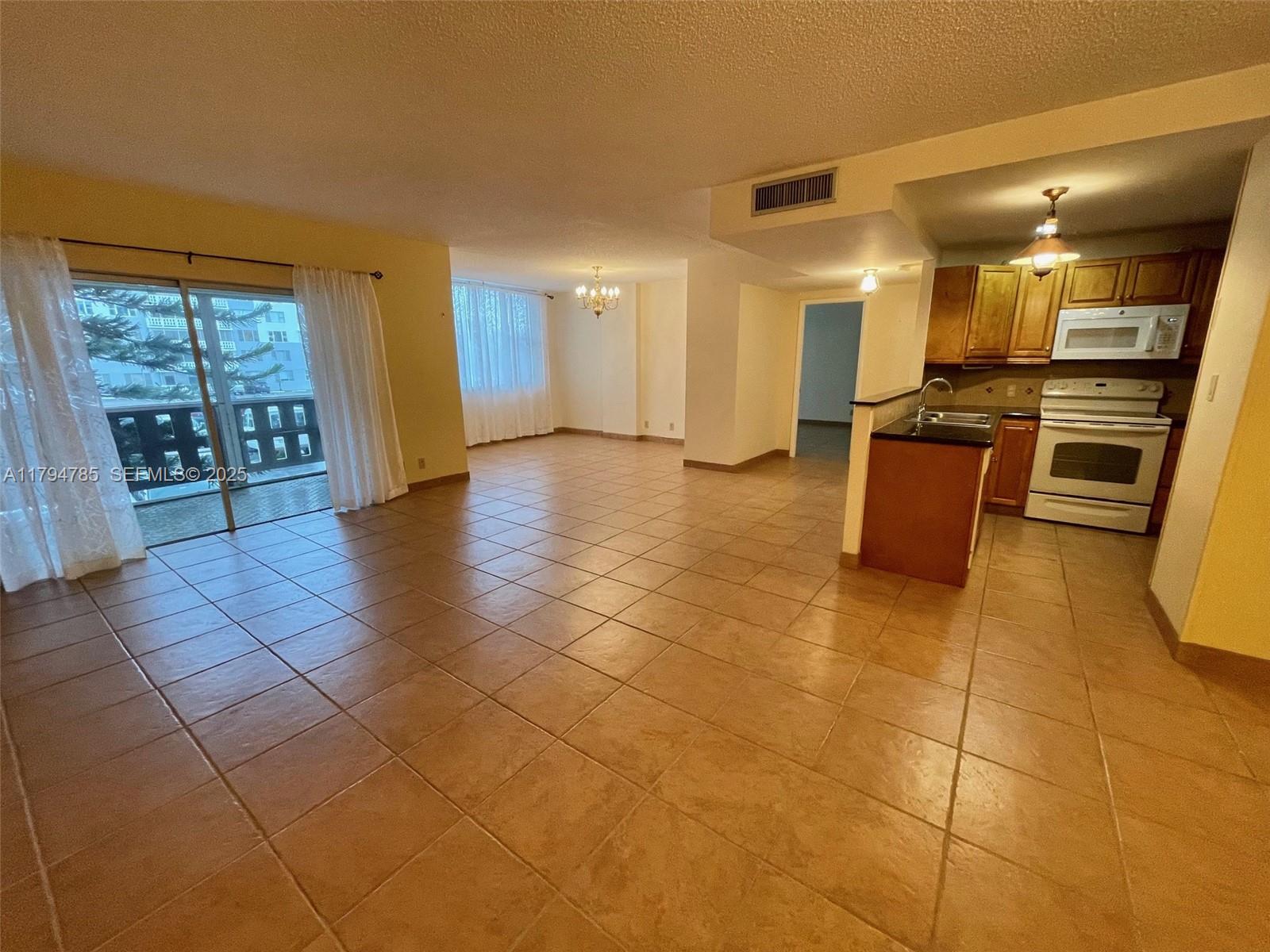 Beautifully maintained condo 55+ originally 2BD,  updated kitchen with granite countertops. Tile flooring throughout, updated step-in shower, and private screened balcony. AC replaced in 2023. The building offers 24/7 security, on-site management, a heated pool, clubhouse, BBQ area, extra storage, and laundry rooms on each floor. Enjoy resort-style amenities including tennis, pickleball (membership available), and a 3-mile walking trail. Assigned parking plus plenty of guest parking; the second space may be rented $40/month. HOA includes cable TV, internet, and water. Cats and small caged birds welcome. Move-in ready in a well-managed community with exceptional lifestyle features. Motivated seller. Located minutes from Hollywood beach/boardwalk, I-95 highway, Gulfstream/Race, School, Shops, Restaurants, Hard Rock Casino.