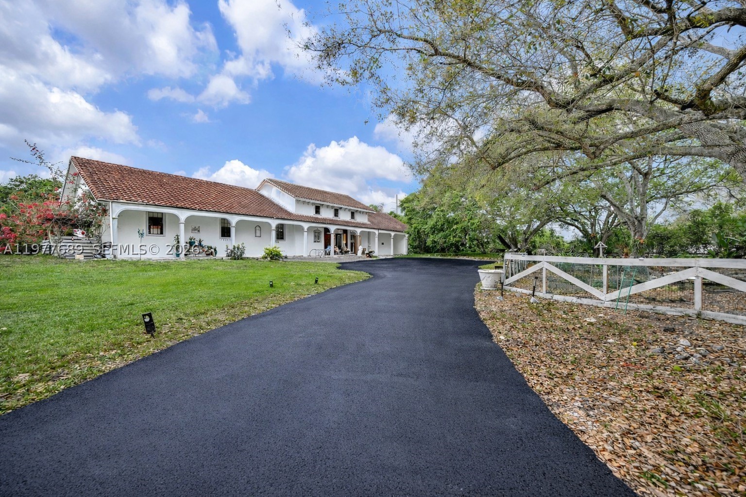 Come make this home your dream home! Set on over two acres, this private corner-lot estate offers exceptional space, privacy, and tranquility. Ideally located across from Weston, near A-rated schools, parks, and outdoor activities. Upon entry, you’re welcomed by the soothing sound of flowing water from a man-made pond nestled among mature oak trees.
Renovated in 2021, the residence features oversized 2x4 porcelain tile flooring, quartz countertops, stainless steel appliances, and a large island ideal for everyday living and entertaining. Notable updates: new roof in 2018; well redone in 2021; pumps and pressure tank replaced in 2023; one AC replaced in 2017 and two ACs in 2021.
The interior is anchored by an expansive primary suite designed as a private retreat, featuring a spa-style bath with floor-to-ceiling tile, freestanding tub, oversized shower, and office. A split floor plan provides privacy, with two bedrooms on one wing and three on the other. Four of the five bedrooms are en suites.
Above the main living area, a loft-style upper level with 24-foot vaulted wood ceilings serves as a lounge with wet bar and balcony. Outdoor living includes a covered terrace, travertine pool deck, resort-style pool and spa, poolside bar, and vine-covered pergola walkway.
Beyond the main residence, the property includes a 1,260 SF air-conditioned garage/workshop with water and electric.
The property is fully fenced with two motorized gates, plus a third RV-access gate with hookups.